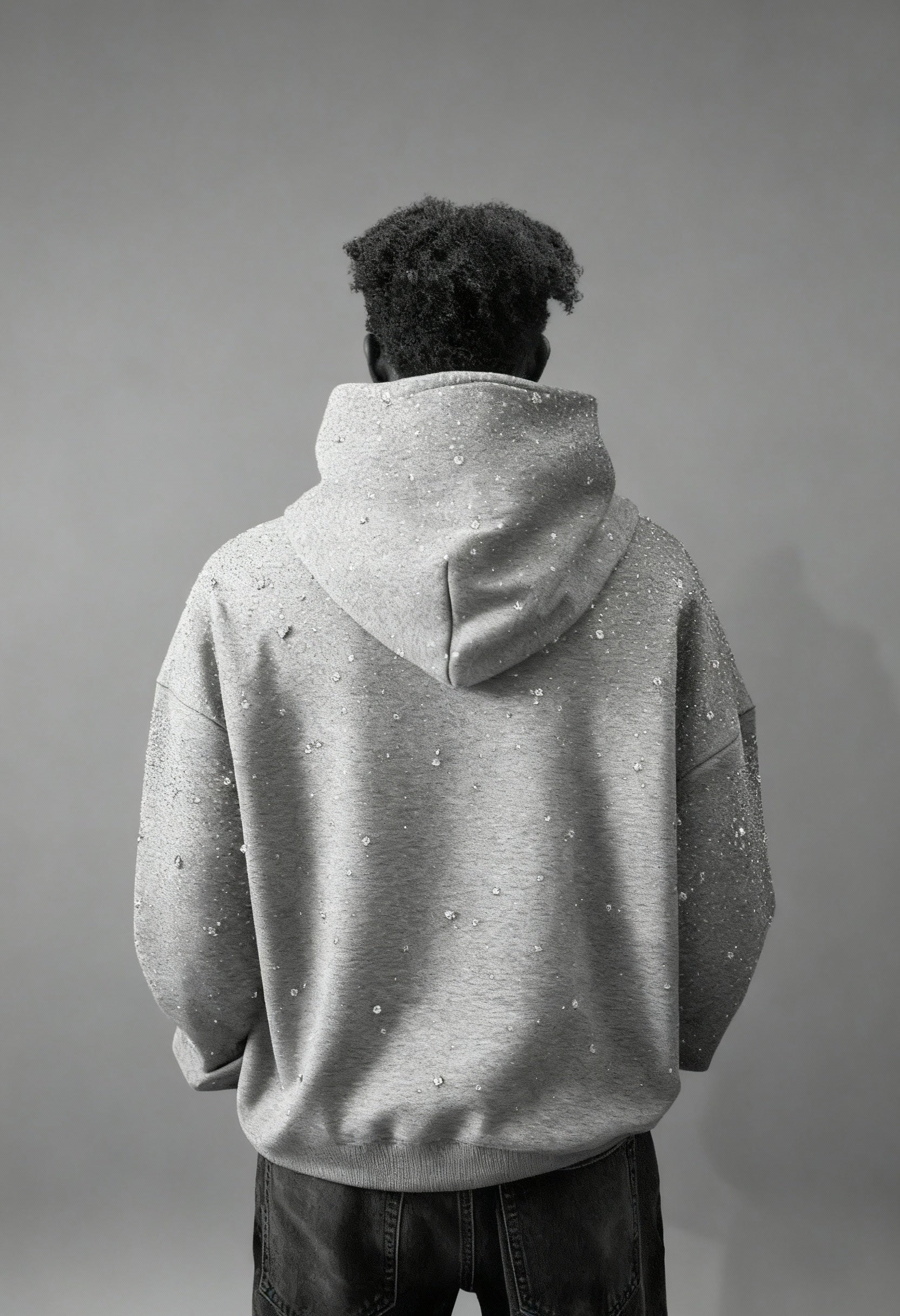 Grauer GABRIEL ABERA Universe Hoodie – männliches Model von hinten, Rhinestone-Veredelung auf Rücken und Kapuze sichtbar, Premium Streetwear.