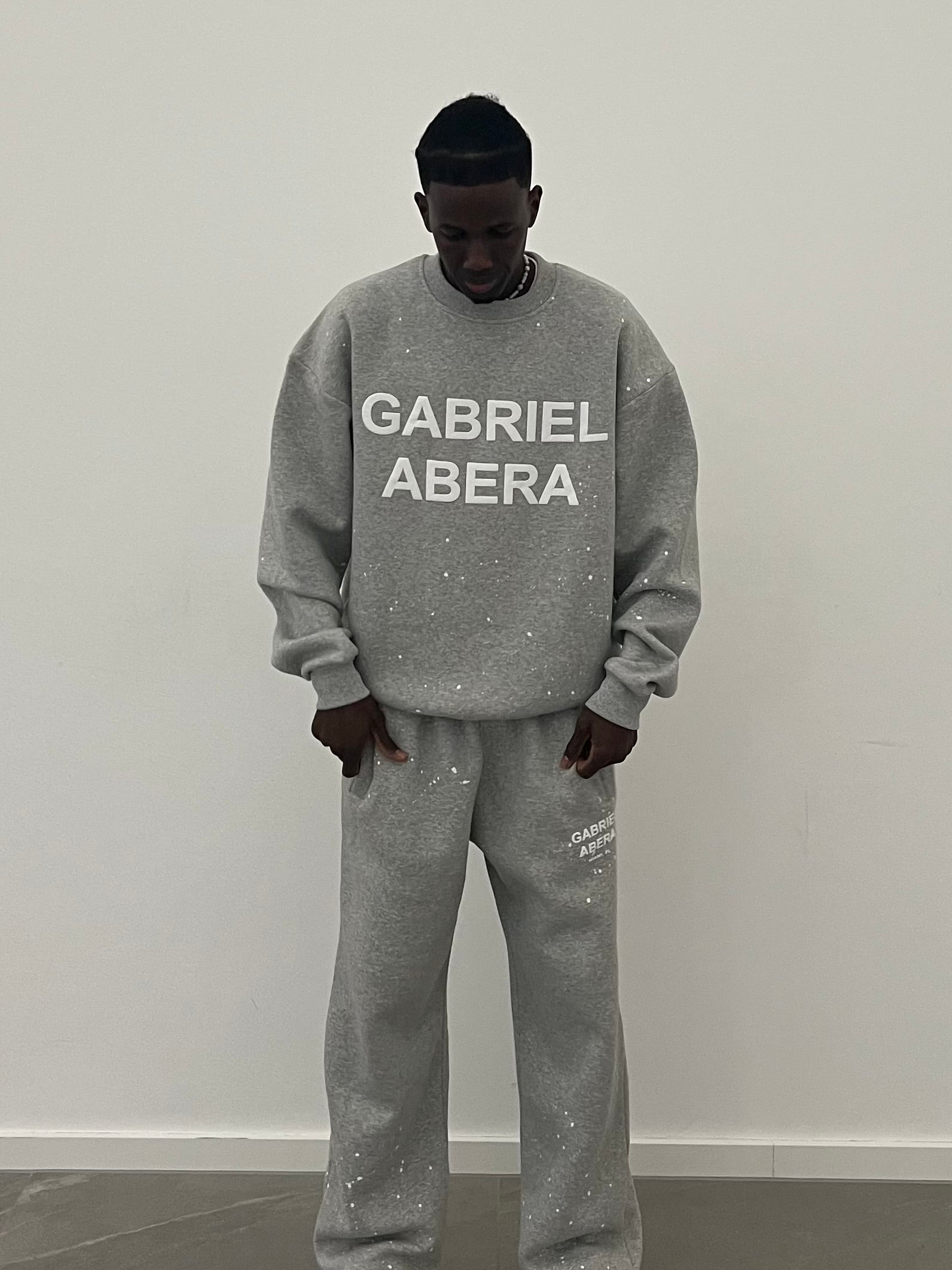 Close-up des weißen Puff Prints auf dem grey Splattered Sweater – ein echtes Statement Piece für modernen Streetwear Style.