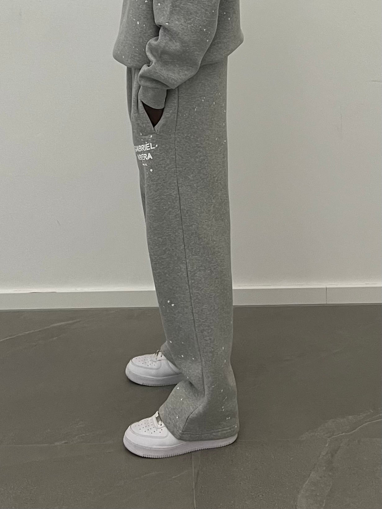 Close-up des weißen Puff Prints auf den grey Splattered Sweatpants – ein echtes Statement Piece für modernen Streetwear Style