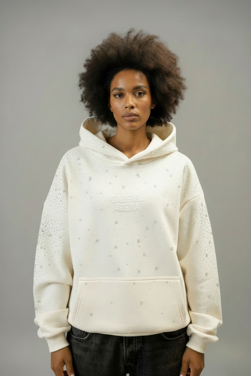 Weibliches Model im GABRIEL ABERA Rhinestone Hoodie Cream White – eleganter Unisex Streetwear Look mit funkelnden Rhinestone-Details.