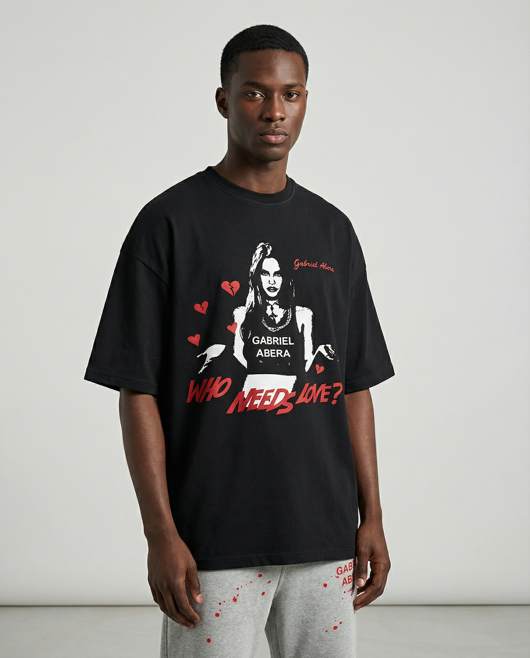 Front view of Black Rebel Heart T-Shirt by Gabriel Abera featuring bold woman print, 'Who Needs Love?' message, and urban streetwear style."