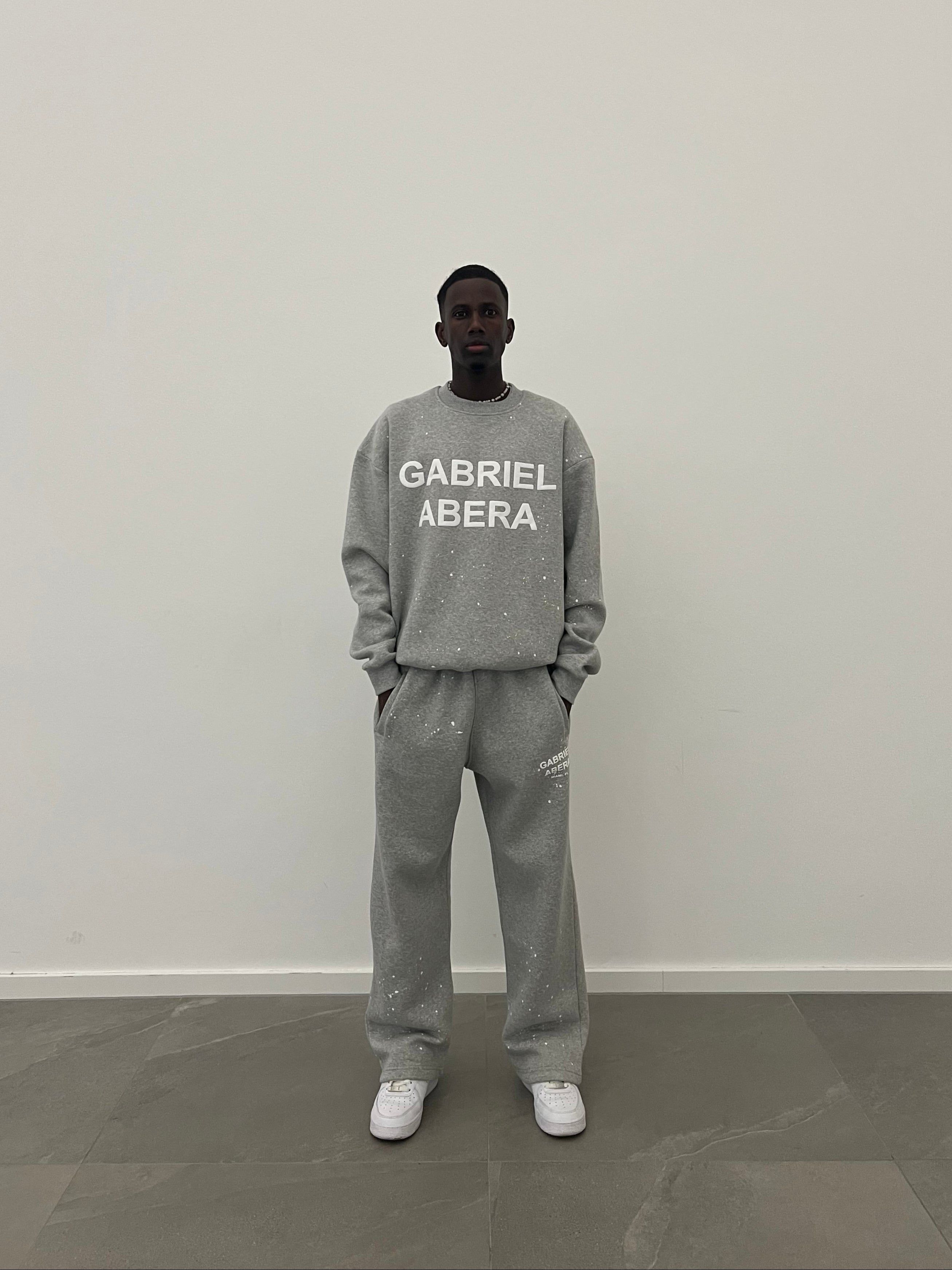 Frontansicht des Models im grauen Splattered Sweater mit artistic Splatter-Design, weichem Cotton Blend und auffälligem white Puff Print.