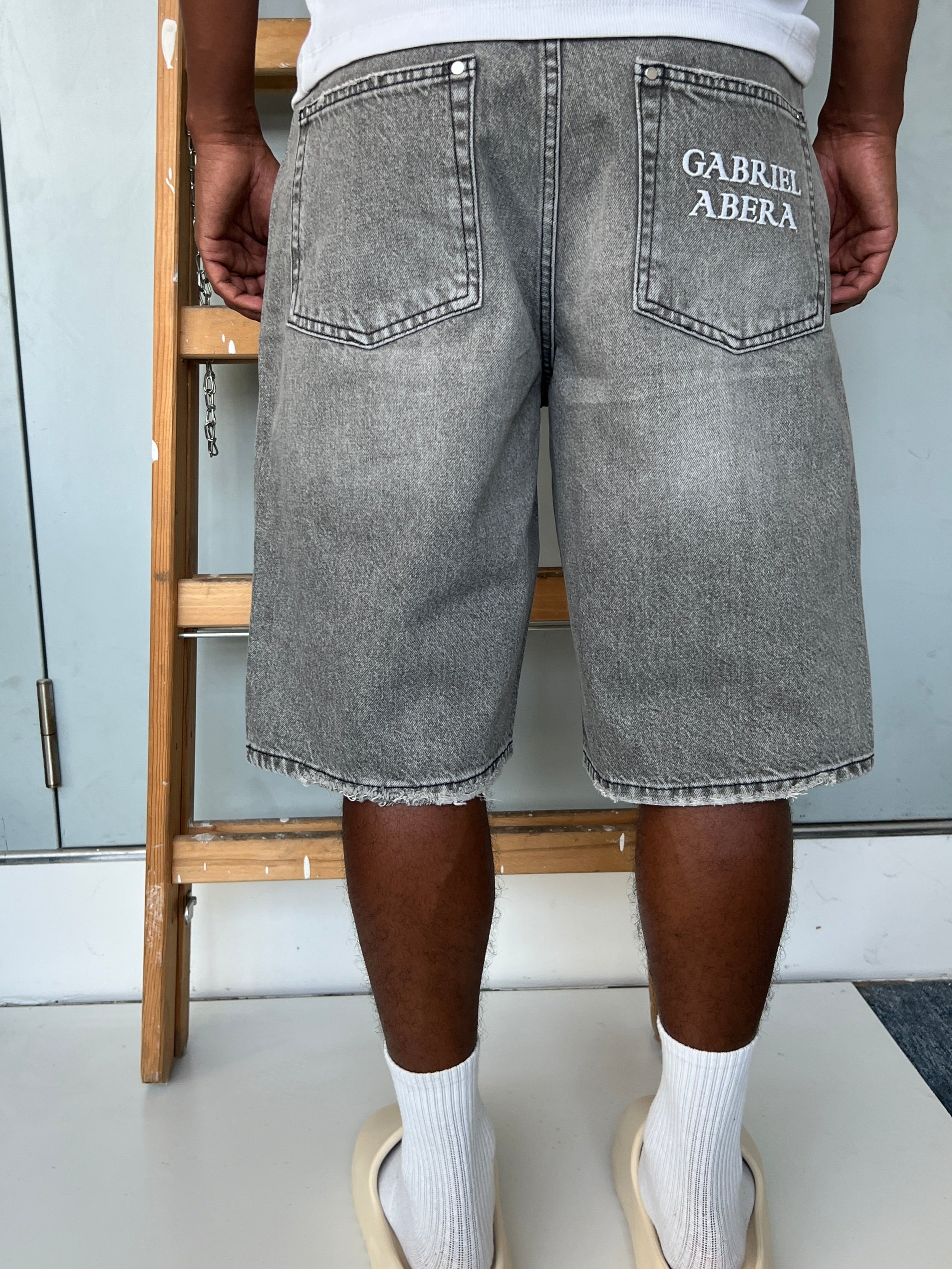 Back view of model wearing Gabriel Abera Rhinestones Denim Jorts, cropped at waist