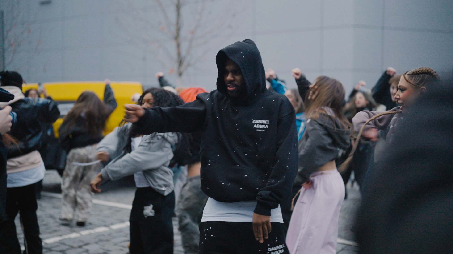 Jason Derulo wearing GABRIEL ABERA paint splattered tracksuit featuring grey hoodie and matching jogger with hand-applied paint design.