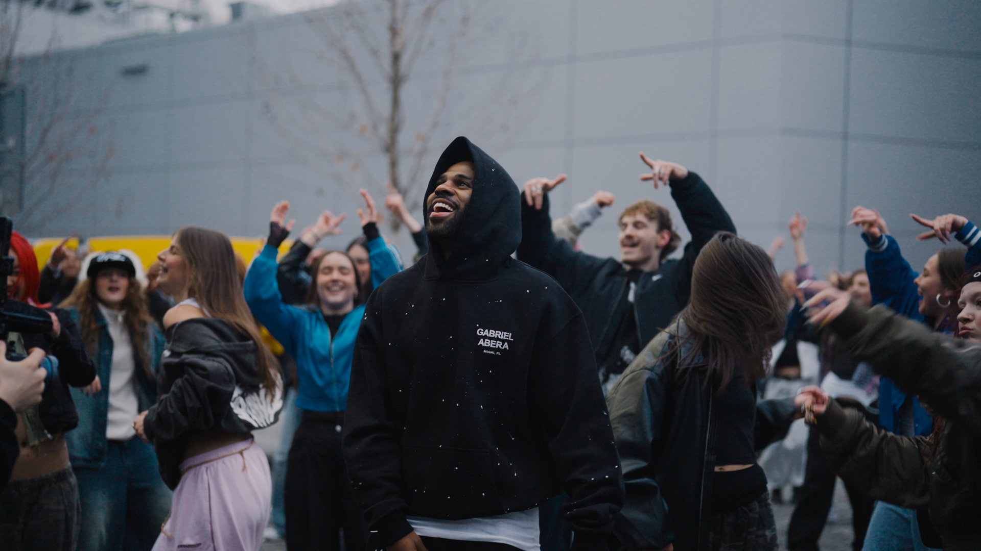 Jason Derulo wearing GABRIEL ABERA paint splattered tracksuit black streetwear hoodie and pants oversized fit.