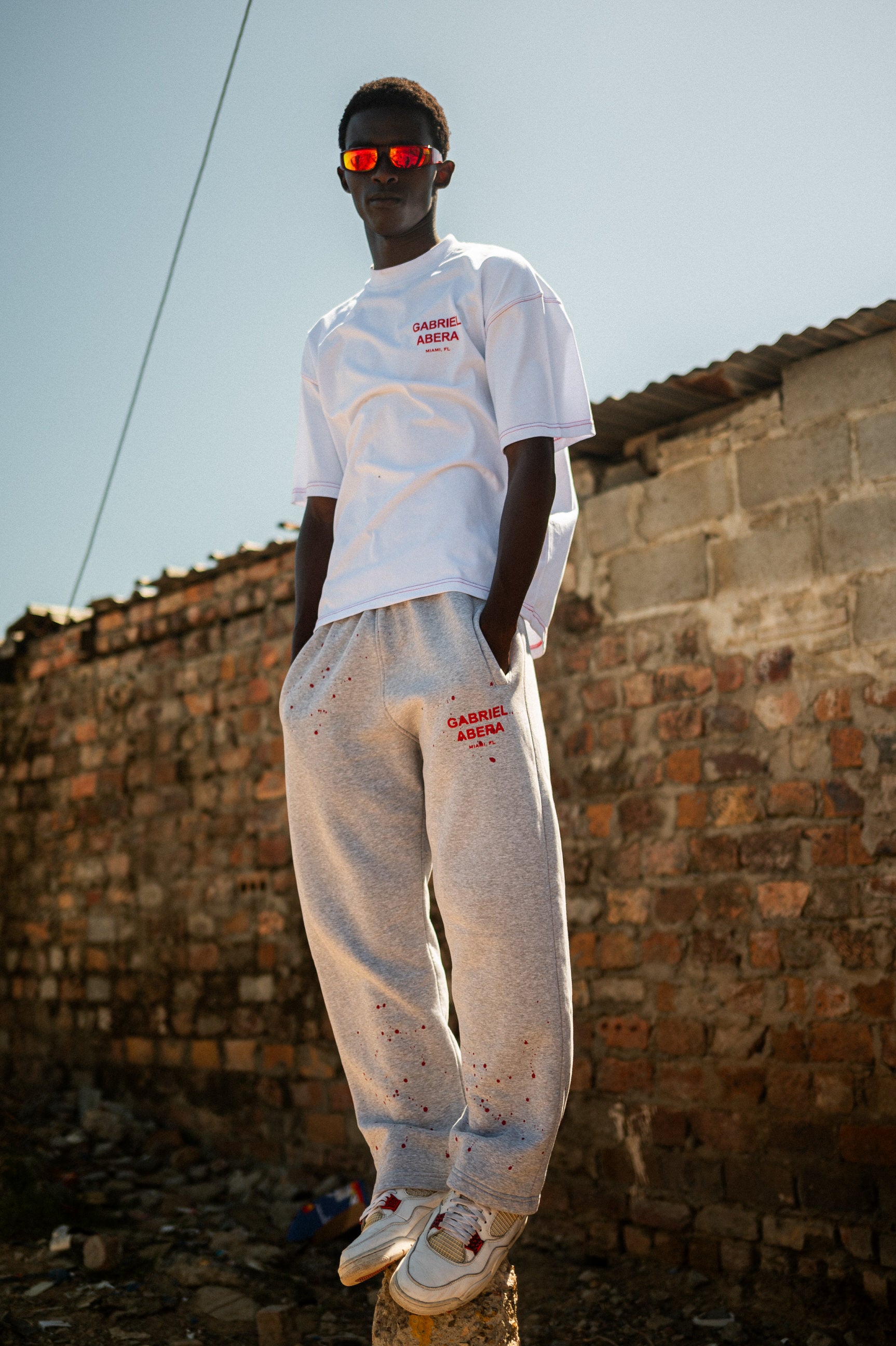 Männliches Model trägt GABRIEL ABERA Splattered Jogginghose mit roten Farbspritzern – Frontansicht im Oversized Streetwear Fit.