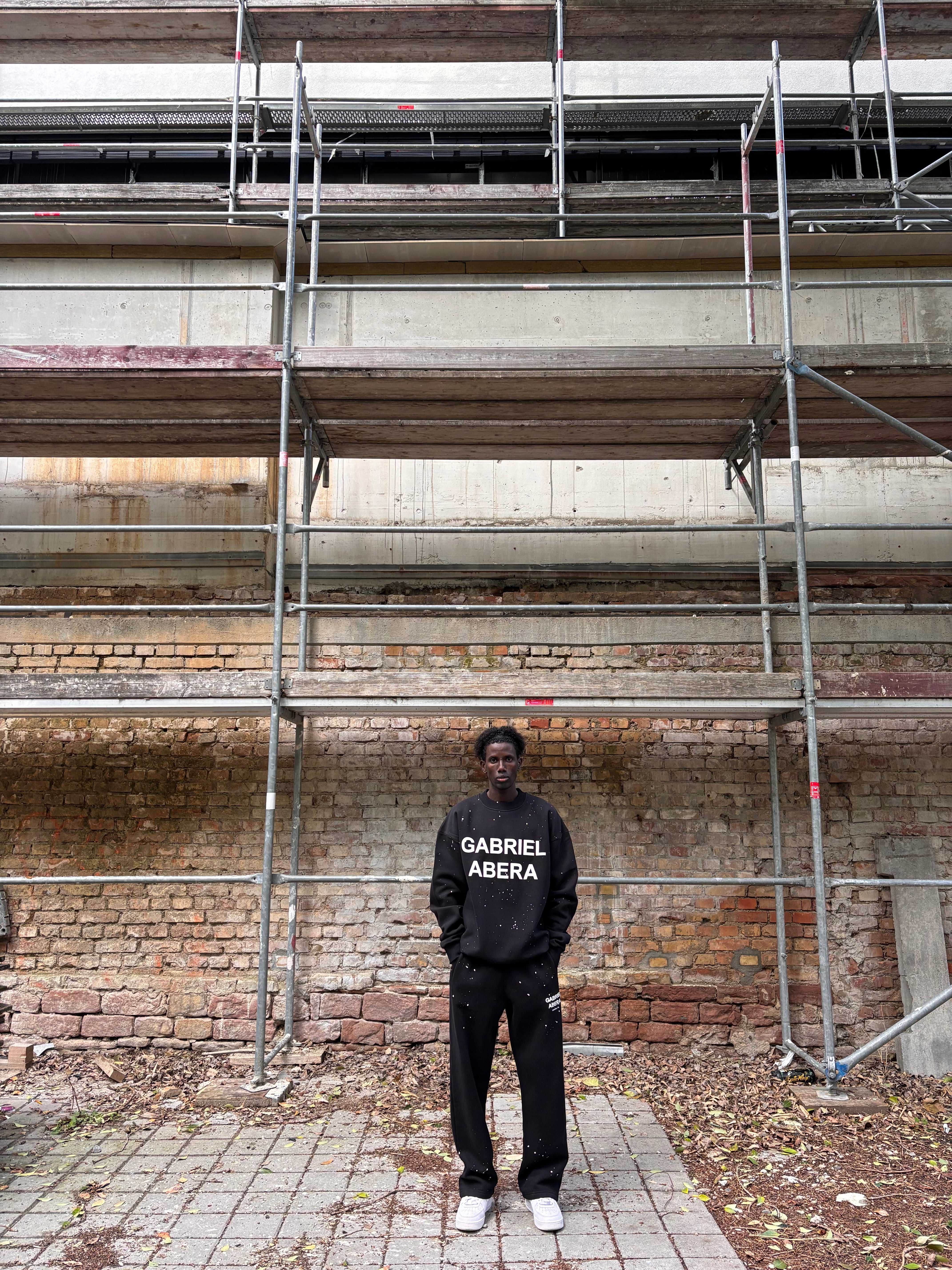 Model trägt komplettes GABRIEL ABERA Set aus Splattered Puff Sweater und Hose – Frontansicht, Oversized Fit mit handgemachten Farbspritzern.