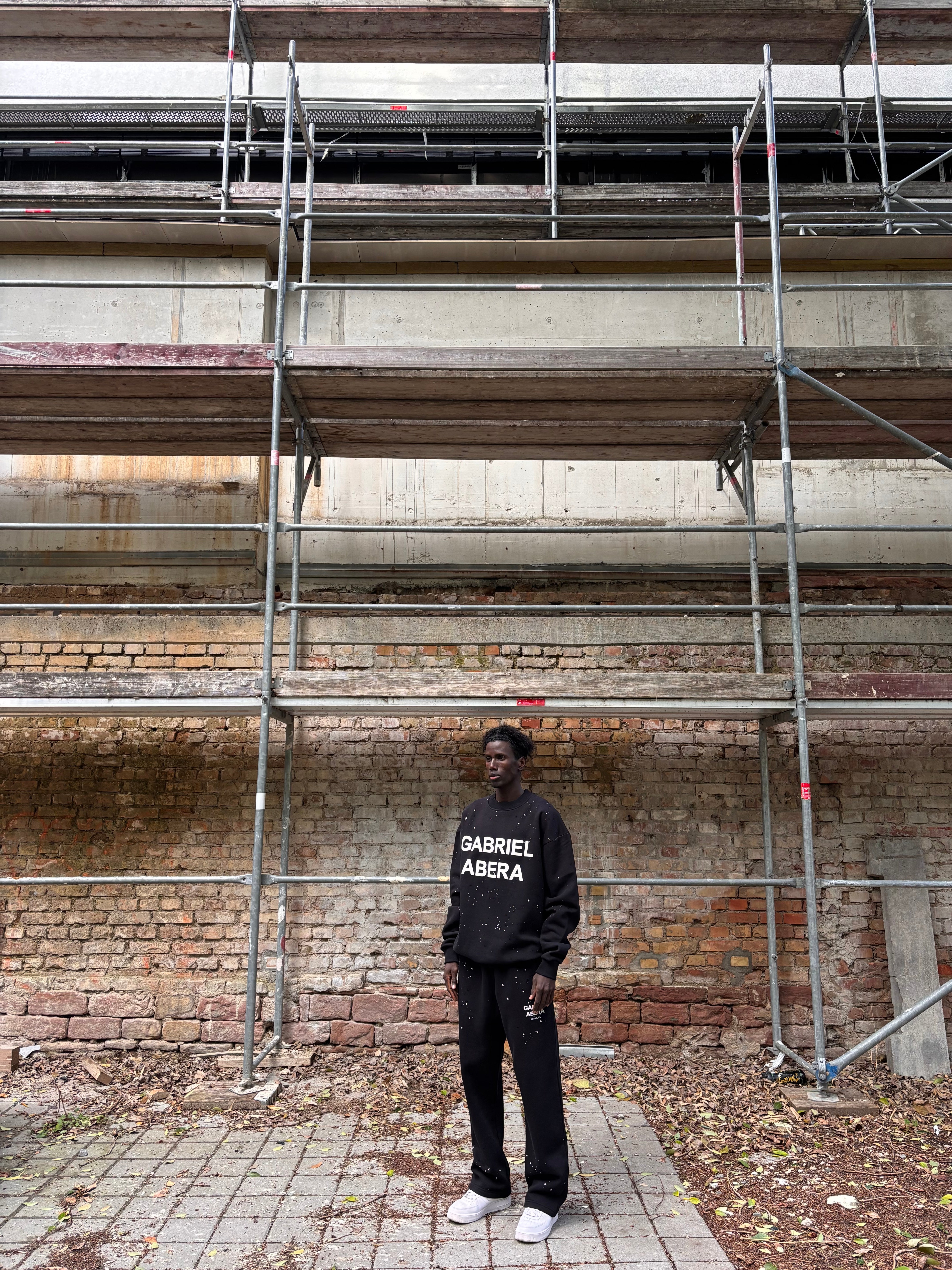 Seitenansicht: Model trägt das GABRIEL ABERA Set aus Splattered Puff Sweater und Hose – Streetwear Look mit lockerer Silhouette und Splatter-Design.