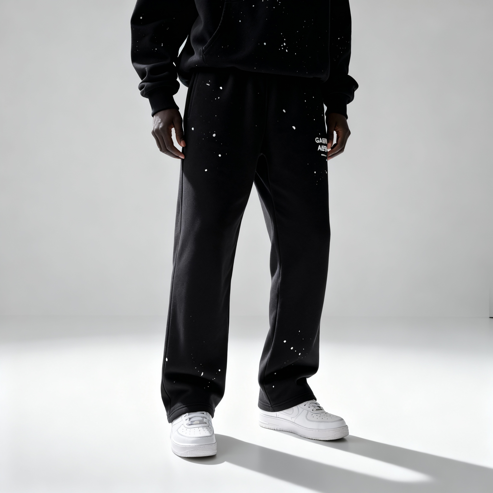 Model trägt GABRIEL ABERA Splattered Sweatpants Black/White – vorneansicht im vollständigen Outfit Look.