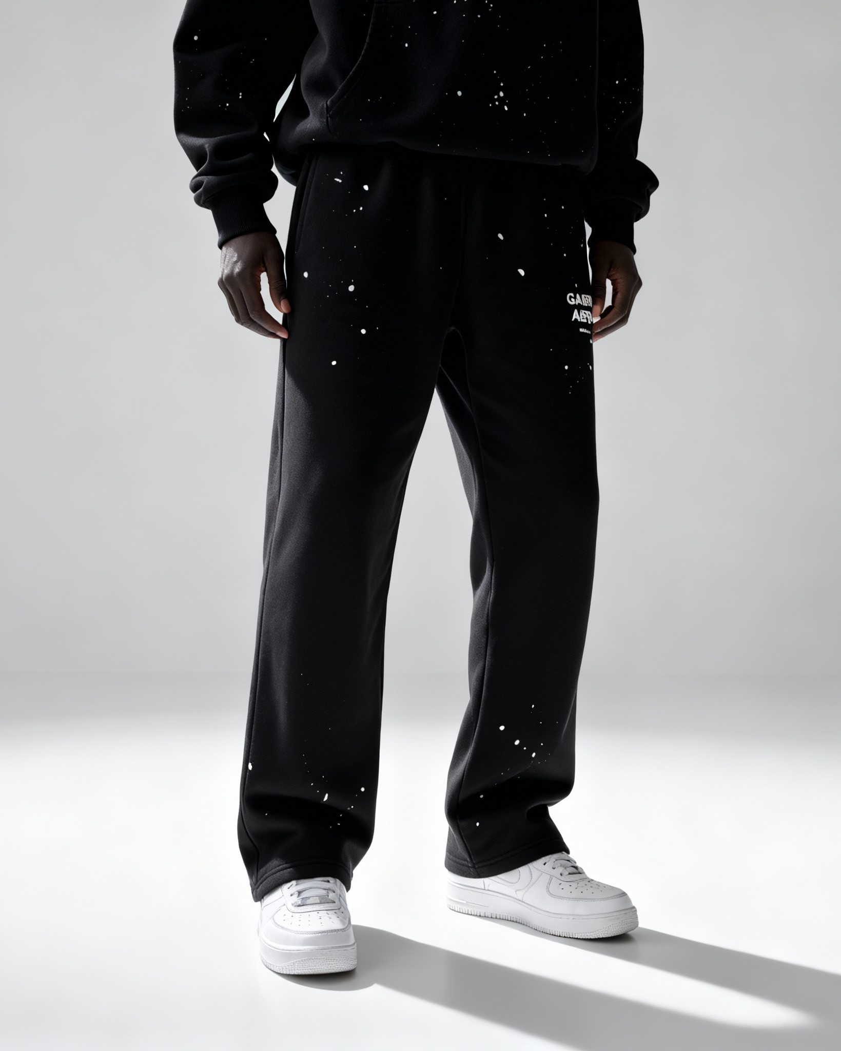Model trägt GABRIEL ABERA Splattered Sweatpants Black/White – vorneansicht im vollständigen Outfit Look.