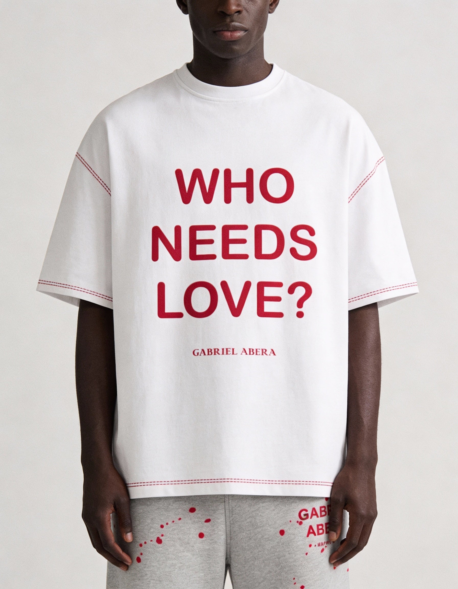 Nahaufnahme des WHO NEEDS LOVE Prints auf weißem GABRIEL ABERA T-Shirt, hochwertige Stoffstruktur und detailreiche Typografie sichtbar