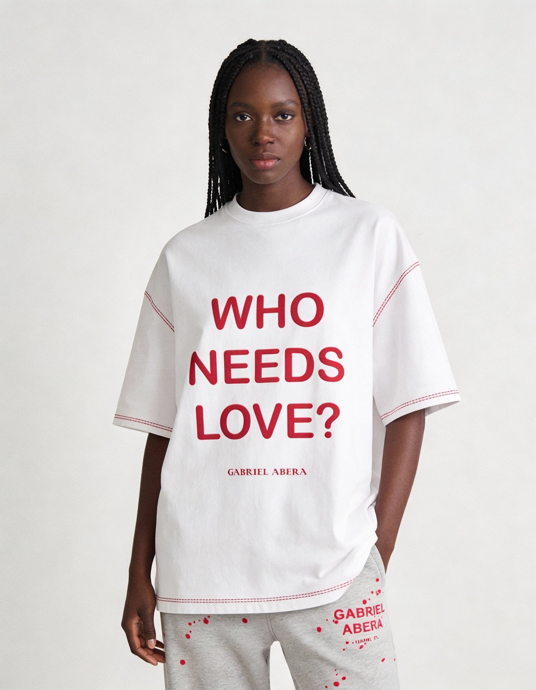 Nahaufnahme des WHO NEEDS LOVE Prints auf weißem GABRIEL ABERA T-Shirt, hochwertige Stoffstruktur und detailreiche Typografie sichtbar