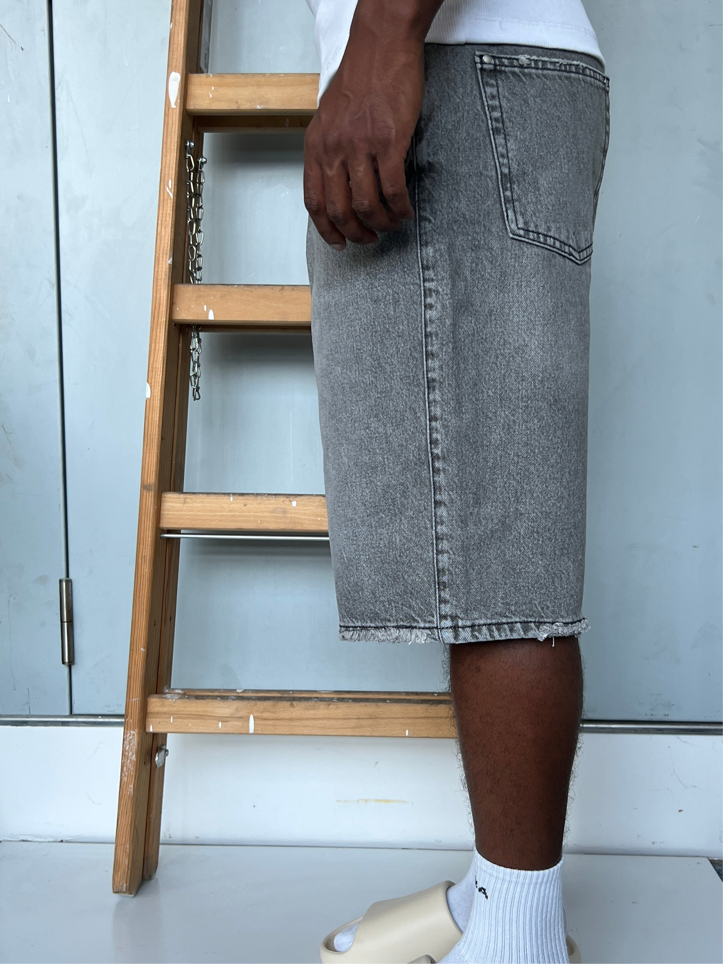 Side view of model wearing Gabriel Abera Rhinestones Denim Jorts, cropped at waist