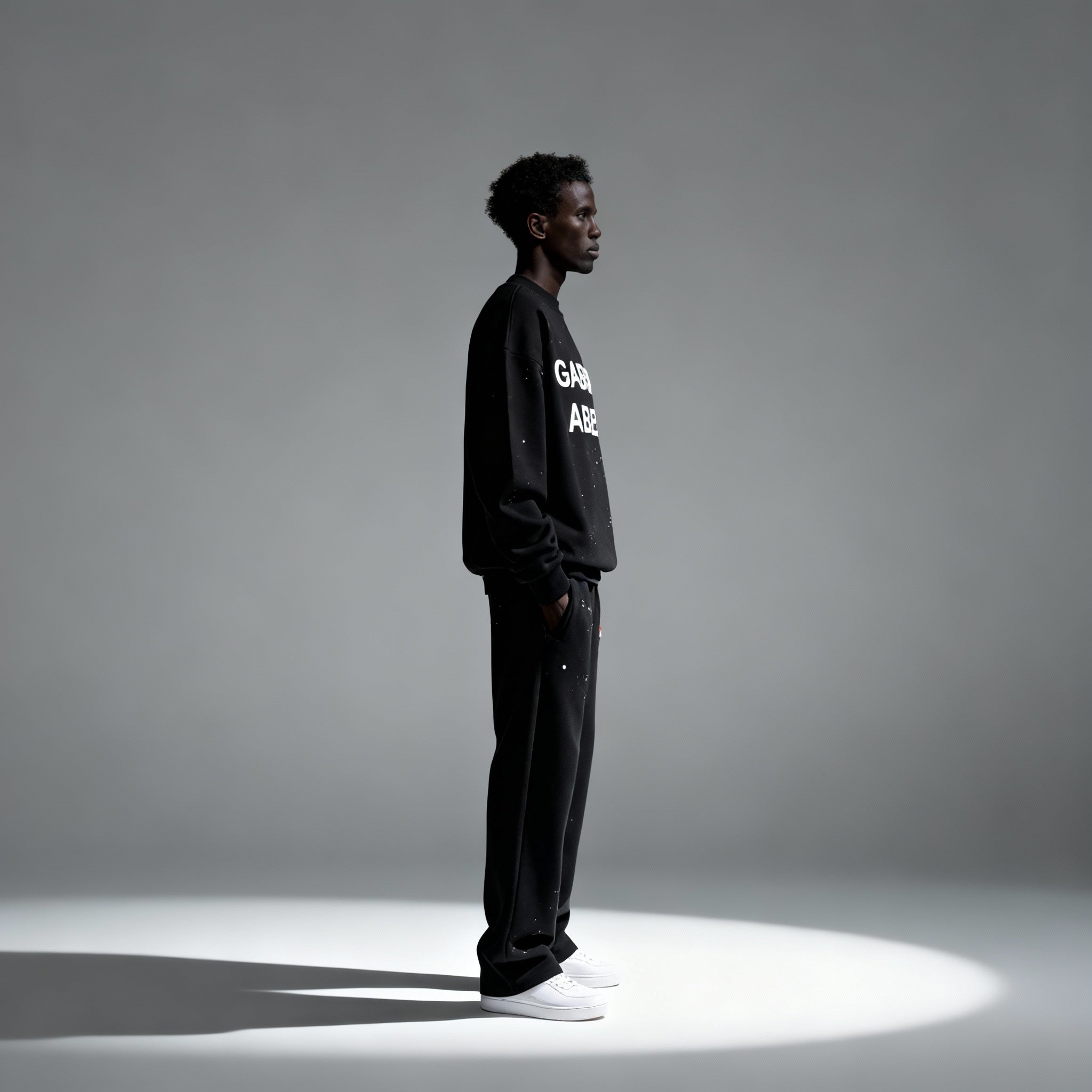 Seitenansicht: Model trägt das GABRIEL ABERA Set aus Splattered Puff Sweater und Hose – Streetwear Look mit lockerer Silhouette und Splatter-Design.