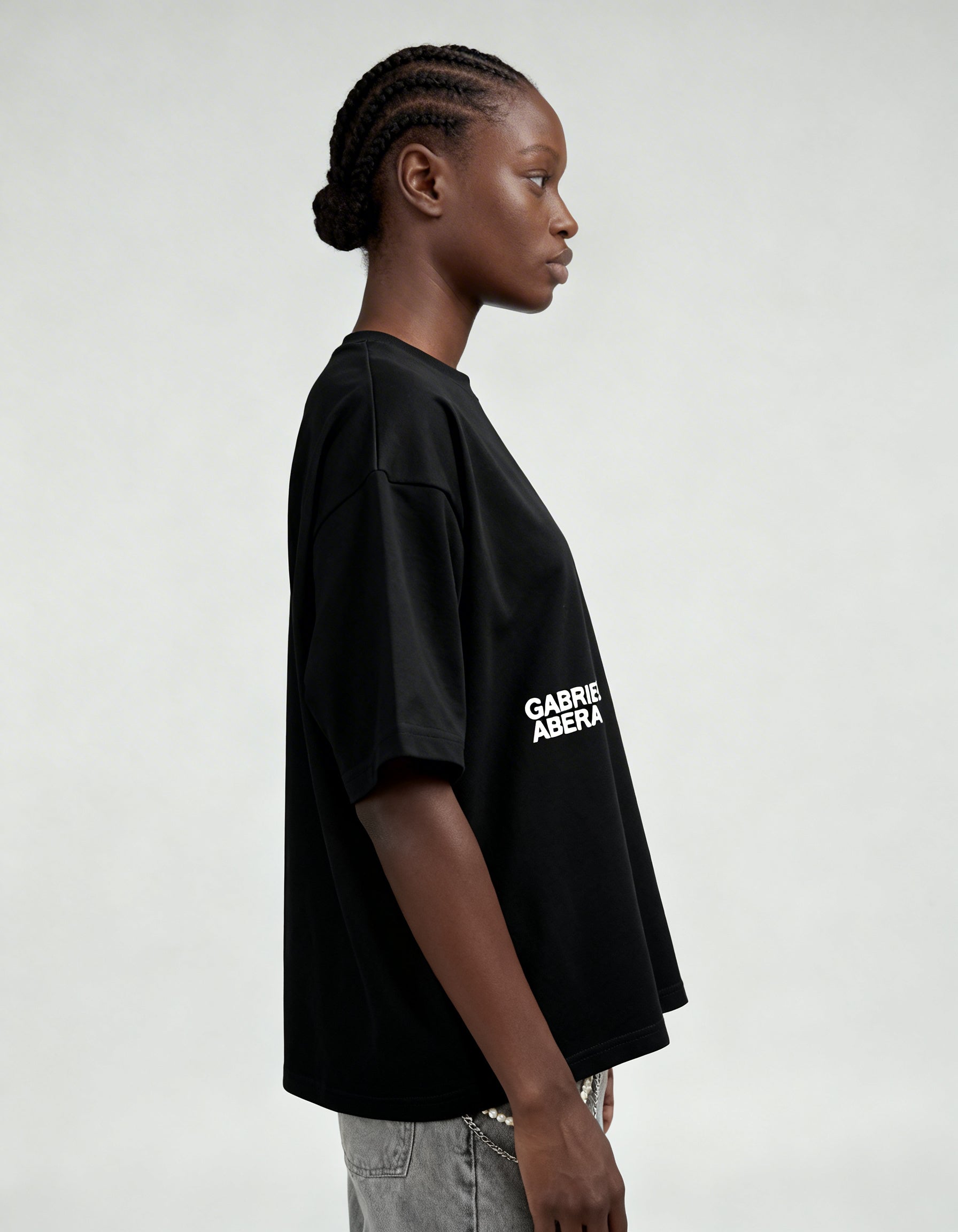 Side view of black boxy oversized T-shirt by GABRIEL ABERA highlighting relaxed streetwear silhouette.