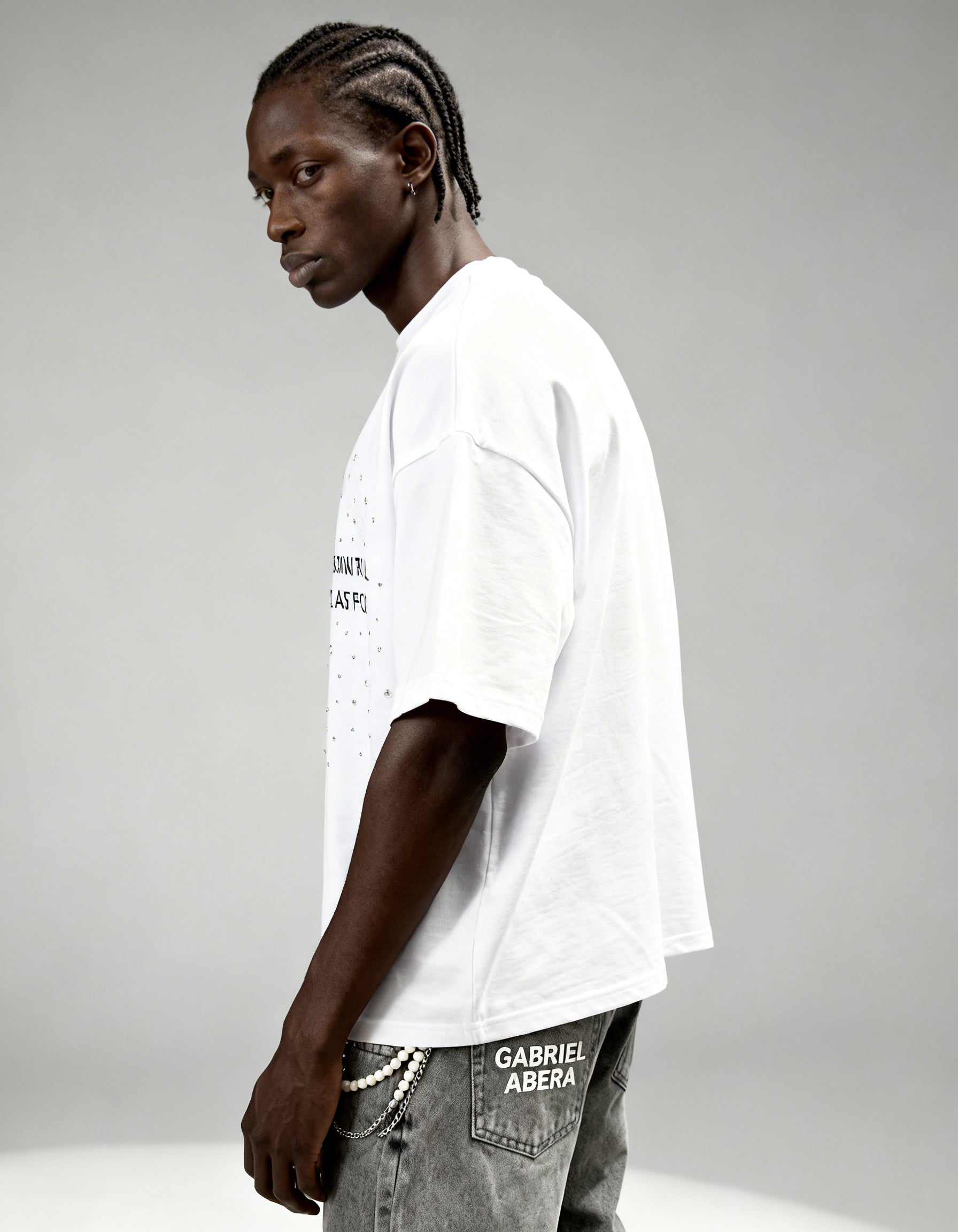 Side view of white boxy rhinestone T-shirt by GABRIEL ABERA showing relaxed streetwear fit and rhinestone details.