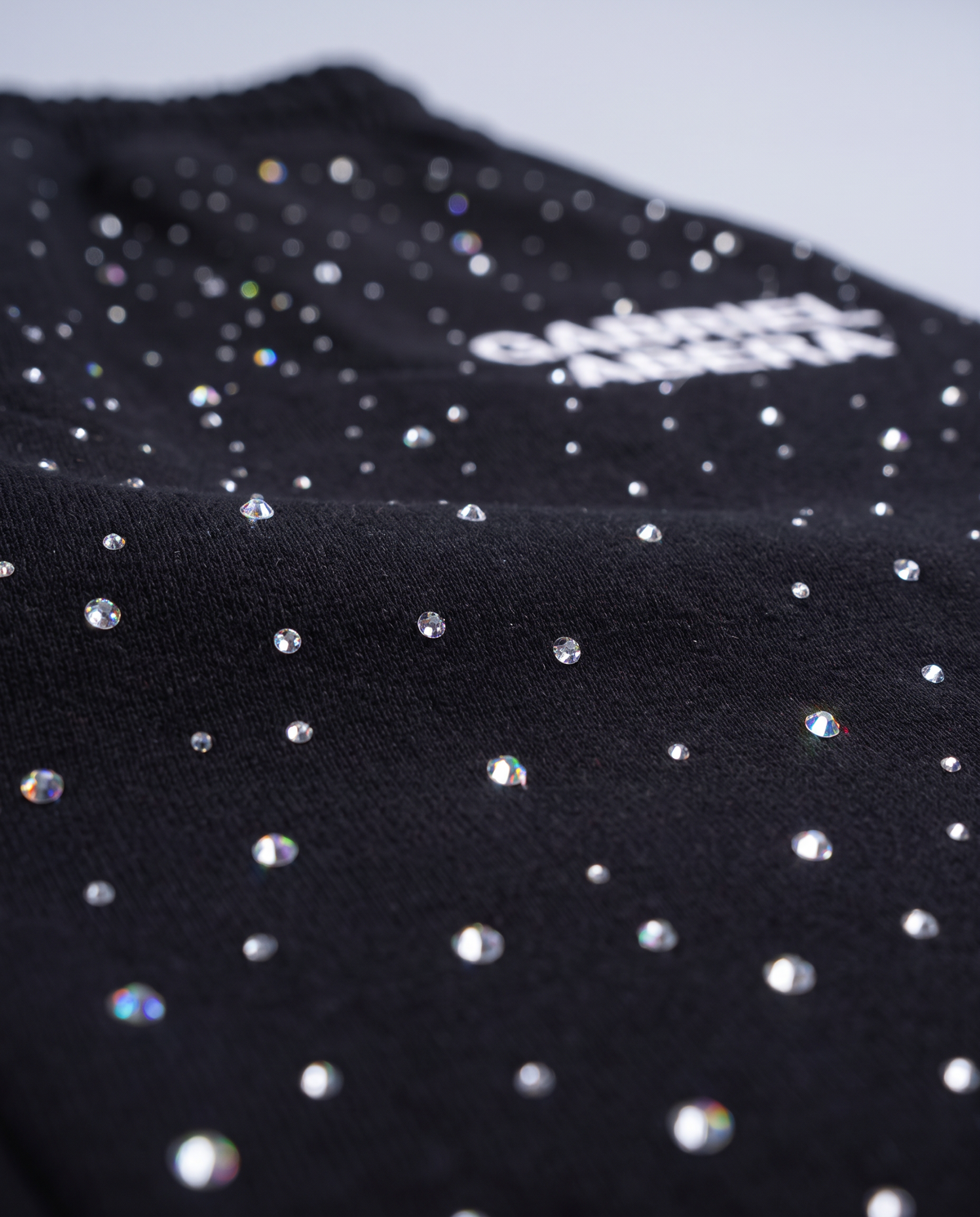 Nahaufnahme des GABRIEL ABERA Logos und der handgesetzten Rhinestones und Strasssteine auf den schwarzen Universe Pants