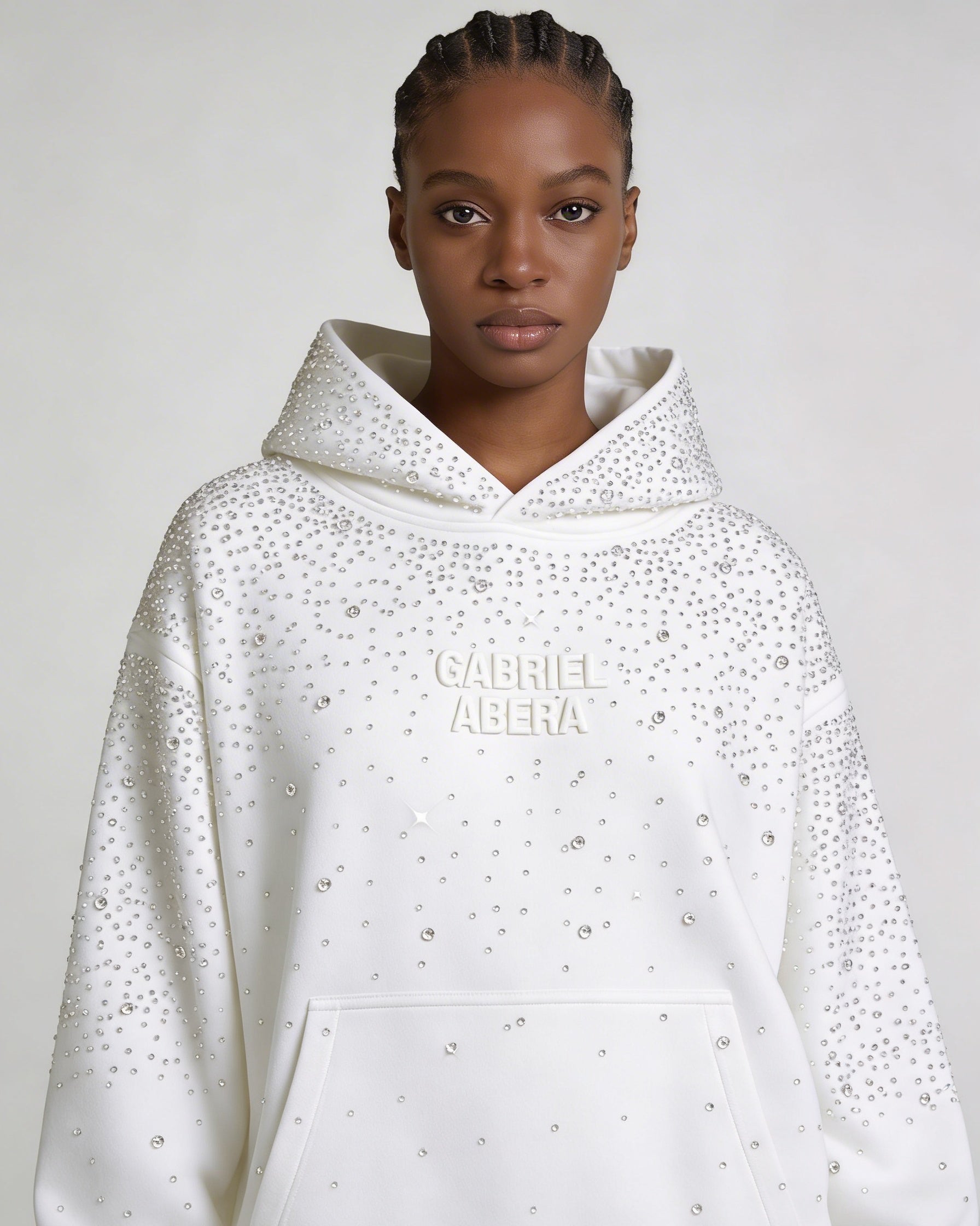 Weibliches Model im GABRIEL ABERA Rhinestone Hoodie Cream White – eleganter Unisex Streetwear Look mit funkelnden Rhinestone-Details.