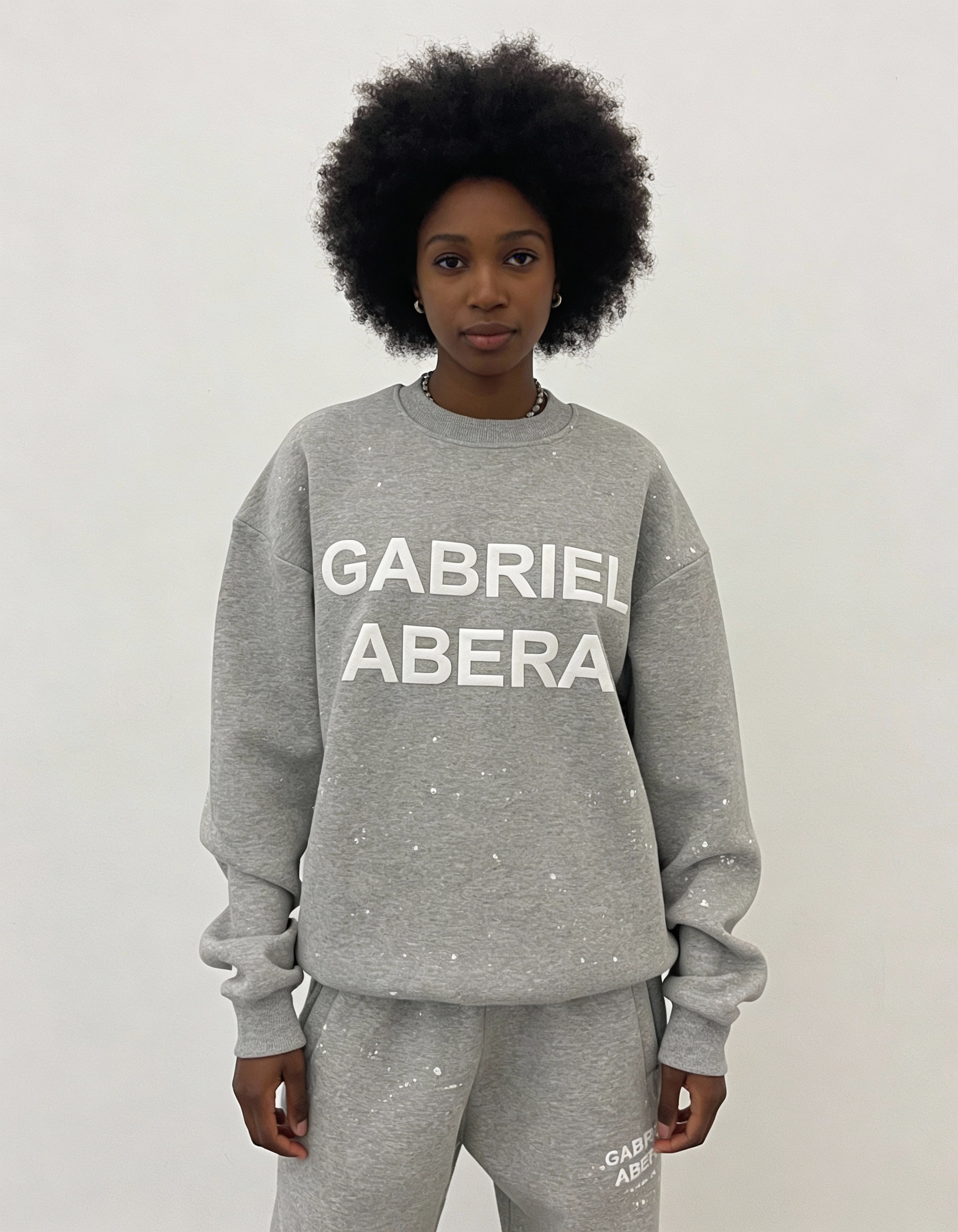 Close-up des weißen Puff Prints auf dem grey Splattered Sweater – ein echtes Statement Piece für modernen Streetwear Style.