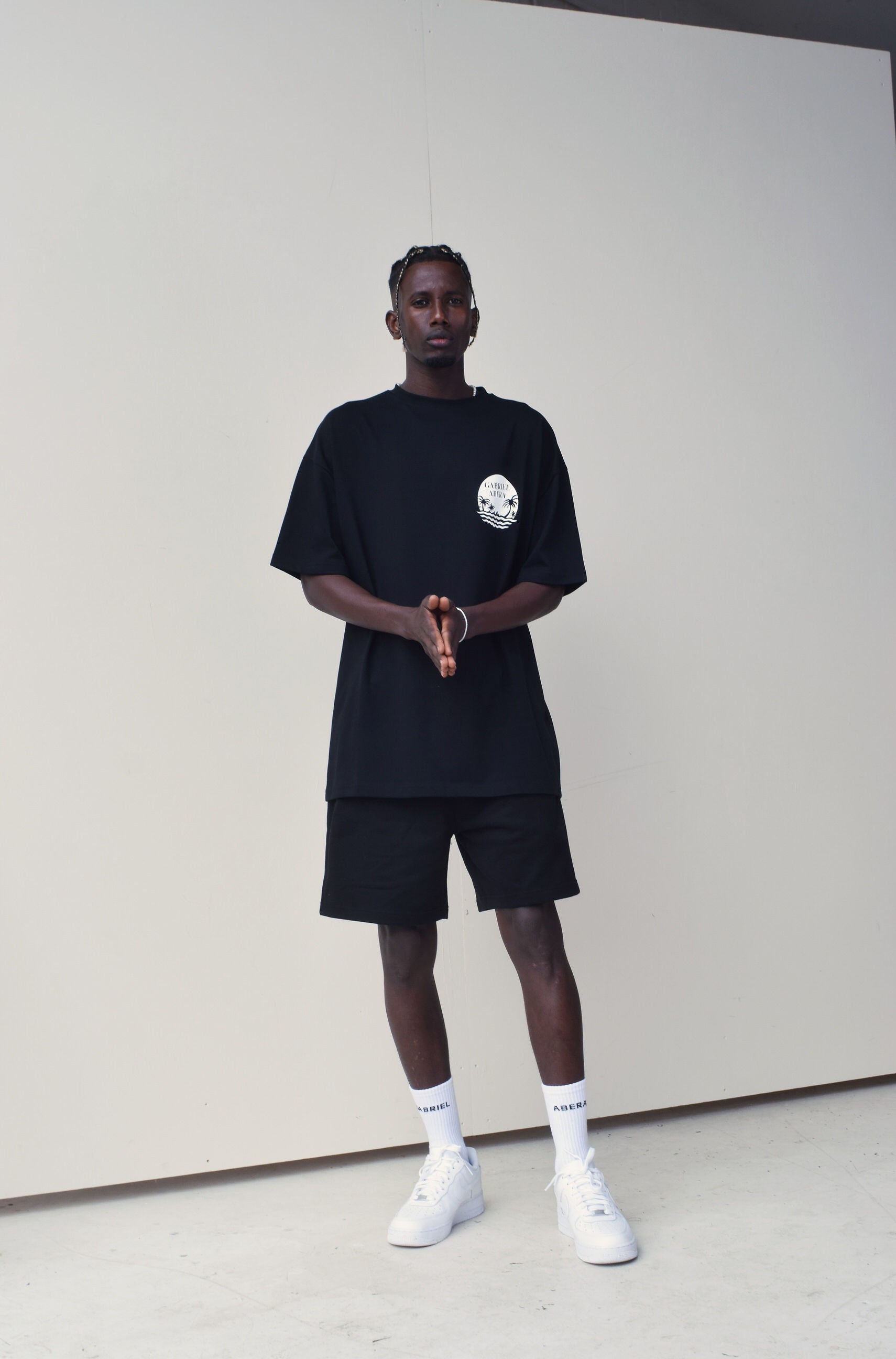 Male Model wearing Black oversize Tshirt with round brand design