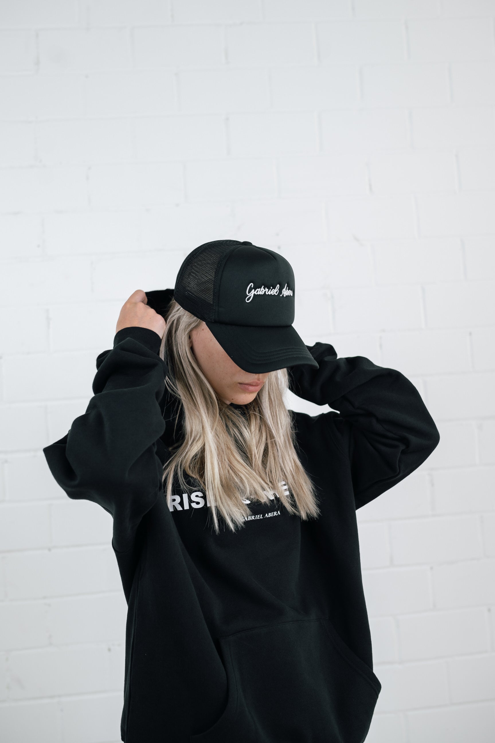 Female model wearing a Black foam cap with brand name embroidery