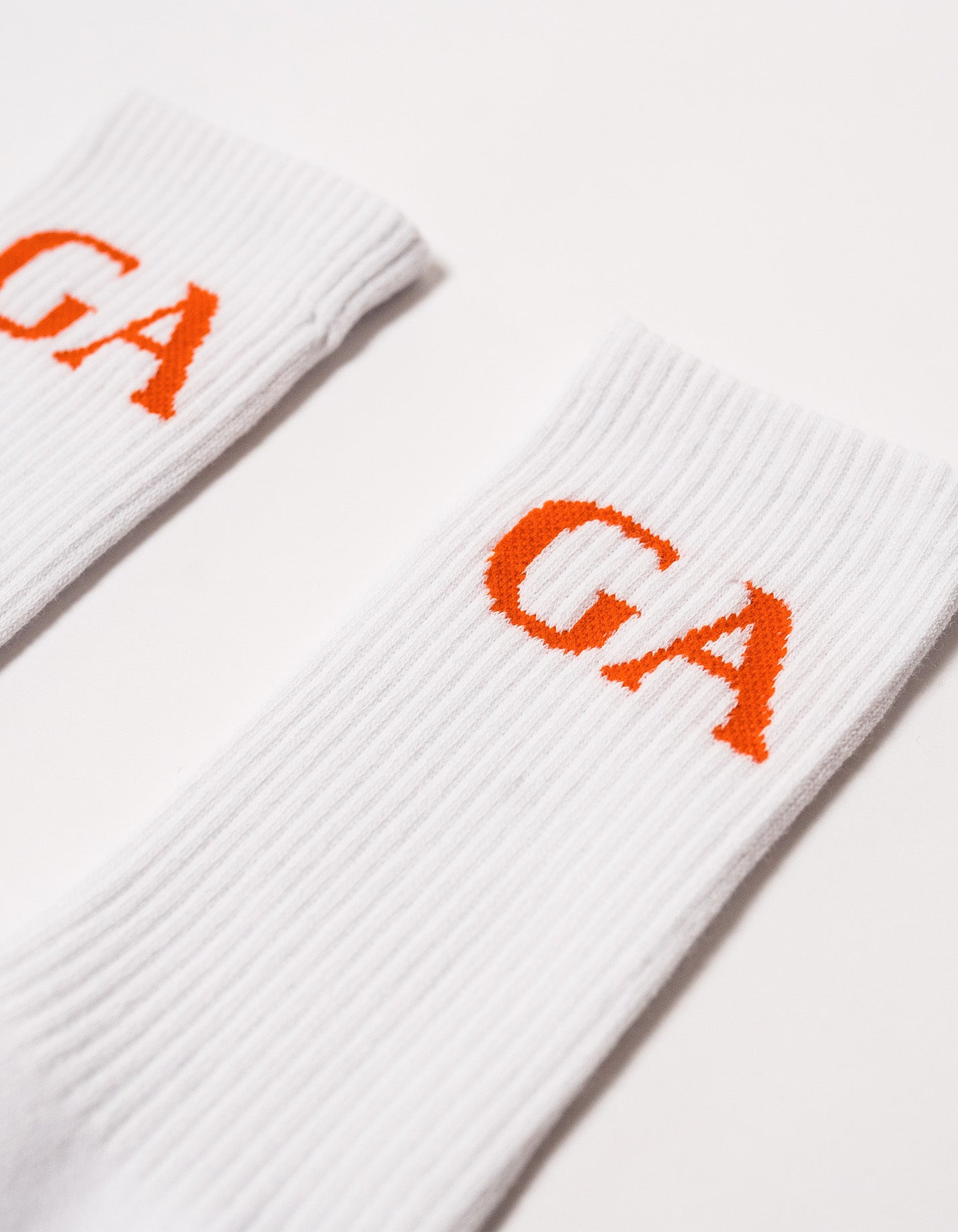 close up of a pair of socks with capital letters GA in orange 