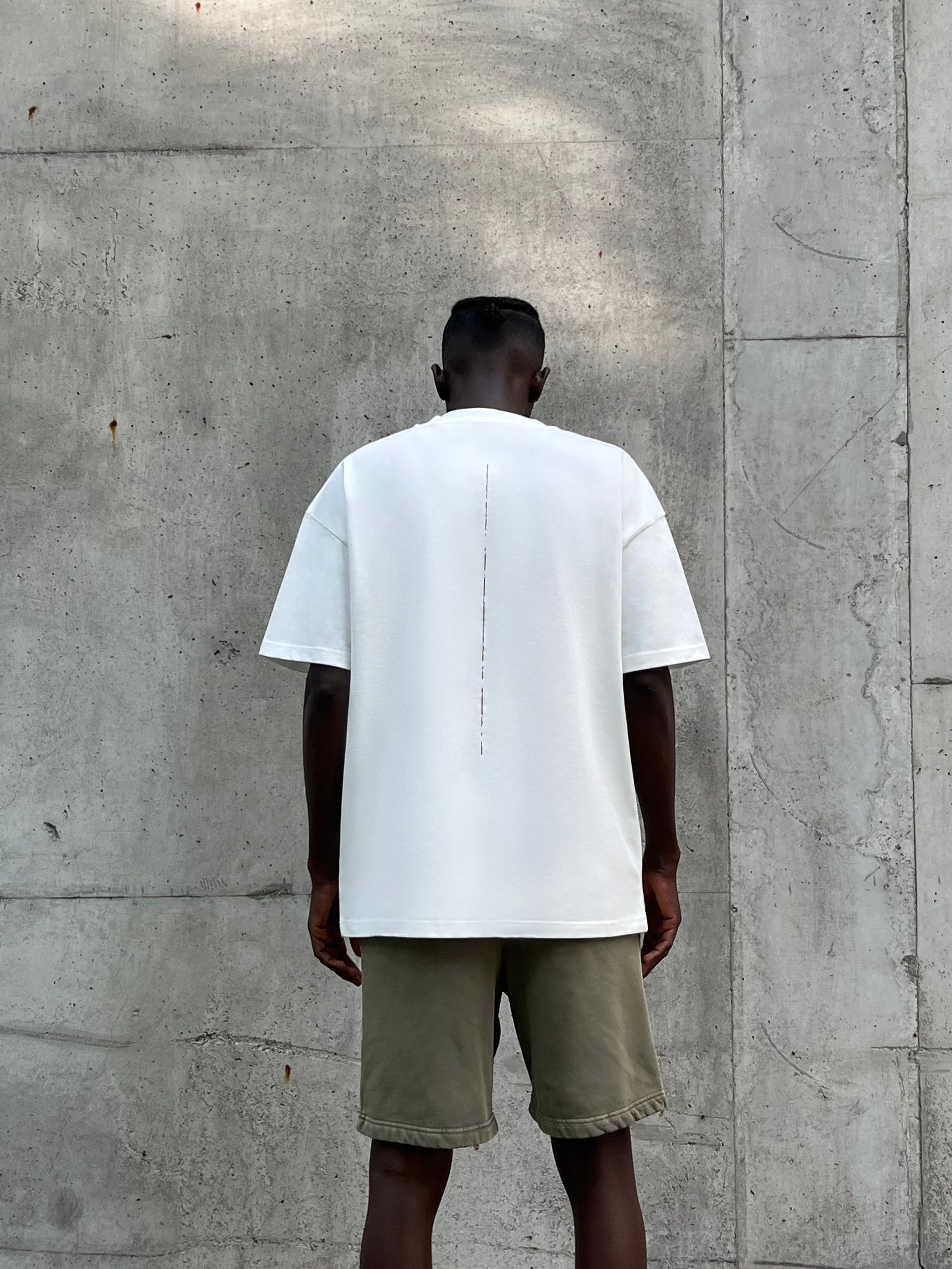 Back view of model wearing GA T-Shirt in cream white, showing straight hem and relaxed silhouette