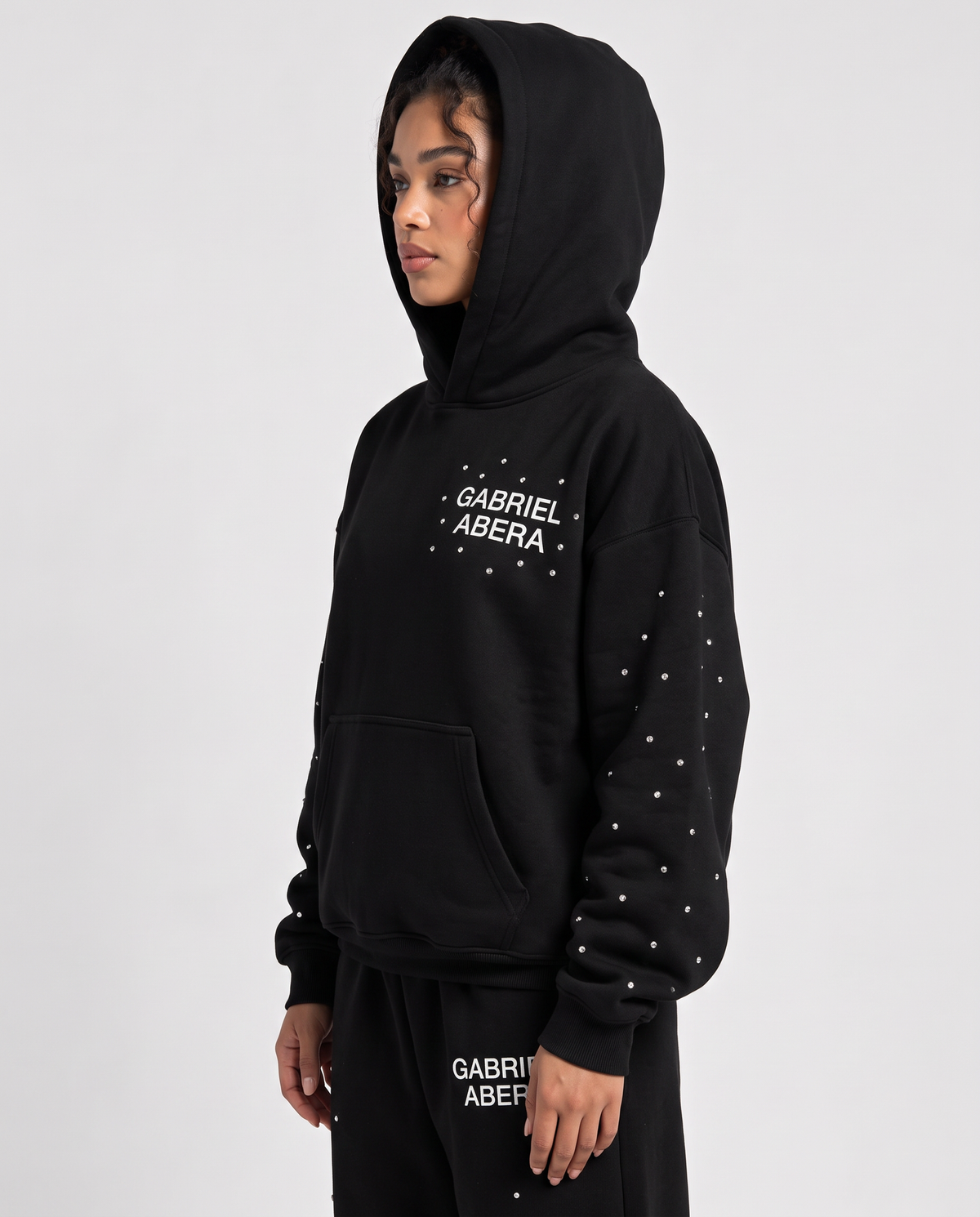 Detailaufnahme des Astral-Rhinestone-Designs auf dem schwarzen GABRIEL ABERA Hoodie