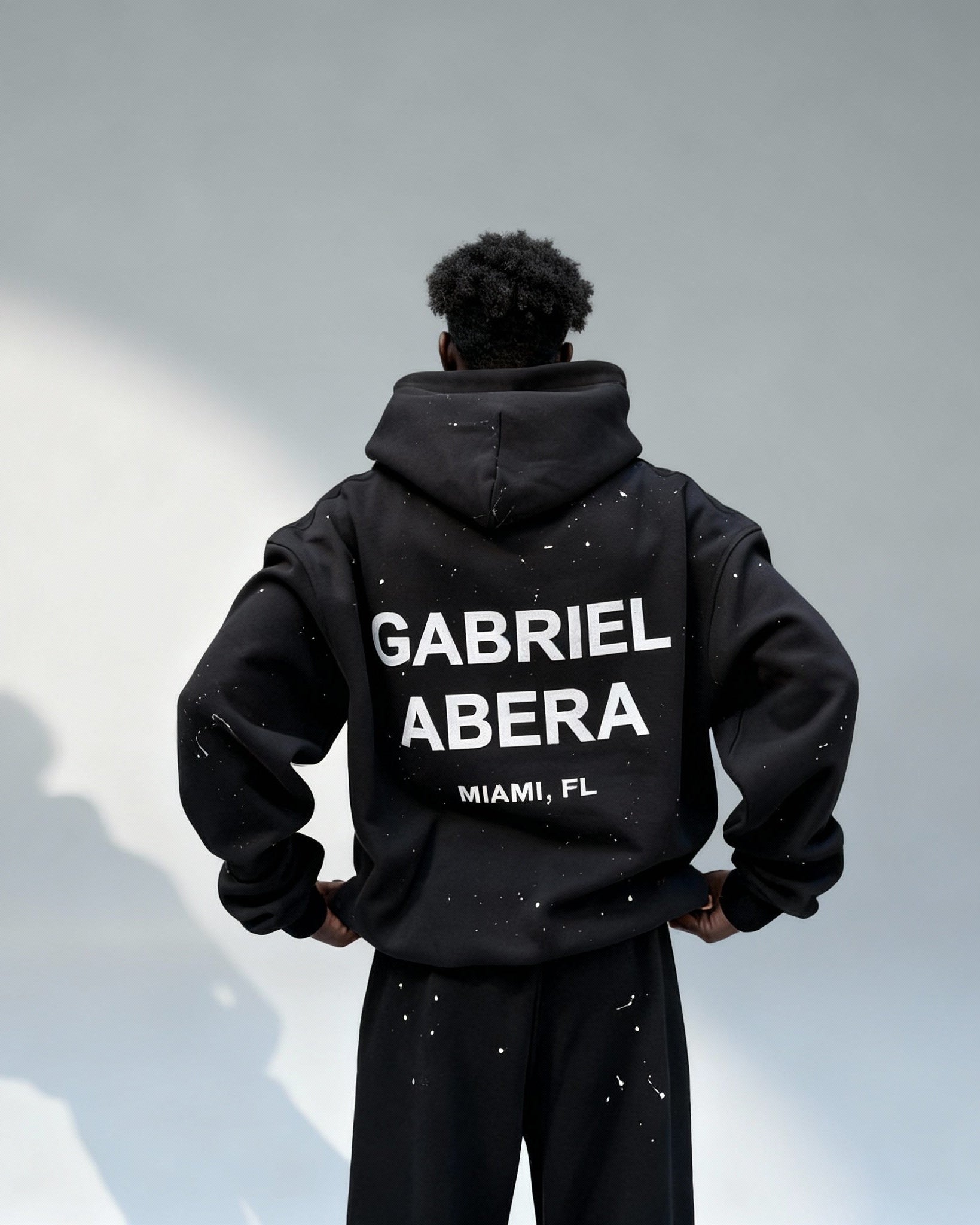 Rückenansicht des GABRIEL ABERA Splattered Puff Hoodie Black/White mit weißem Puff-Print