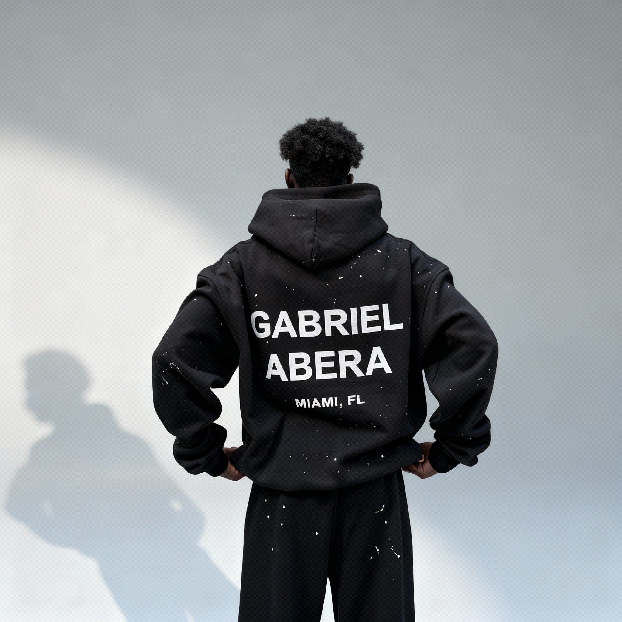 Rückenansicht des GABRIEL ABERA Splattered Puff Hoodie Black/White mit weißem Puff-Print