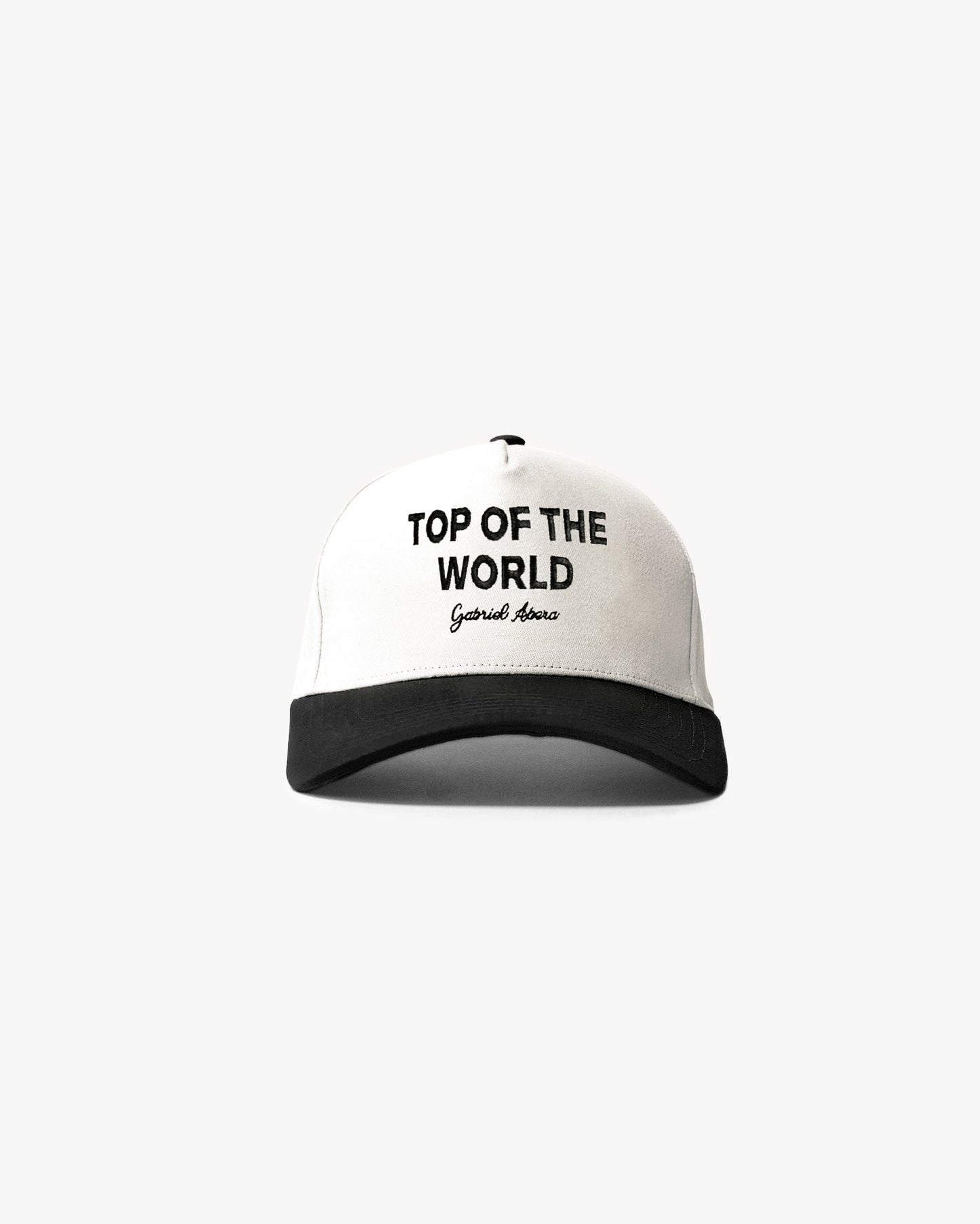 White cap with black shield and black top of the world embroidery in the front 