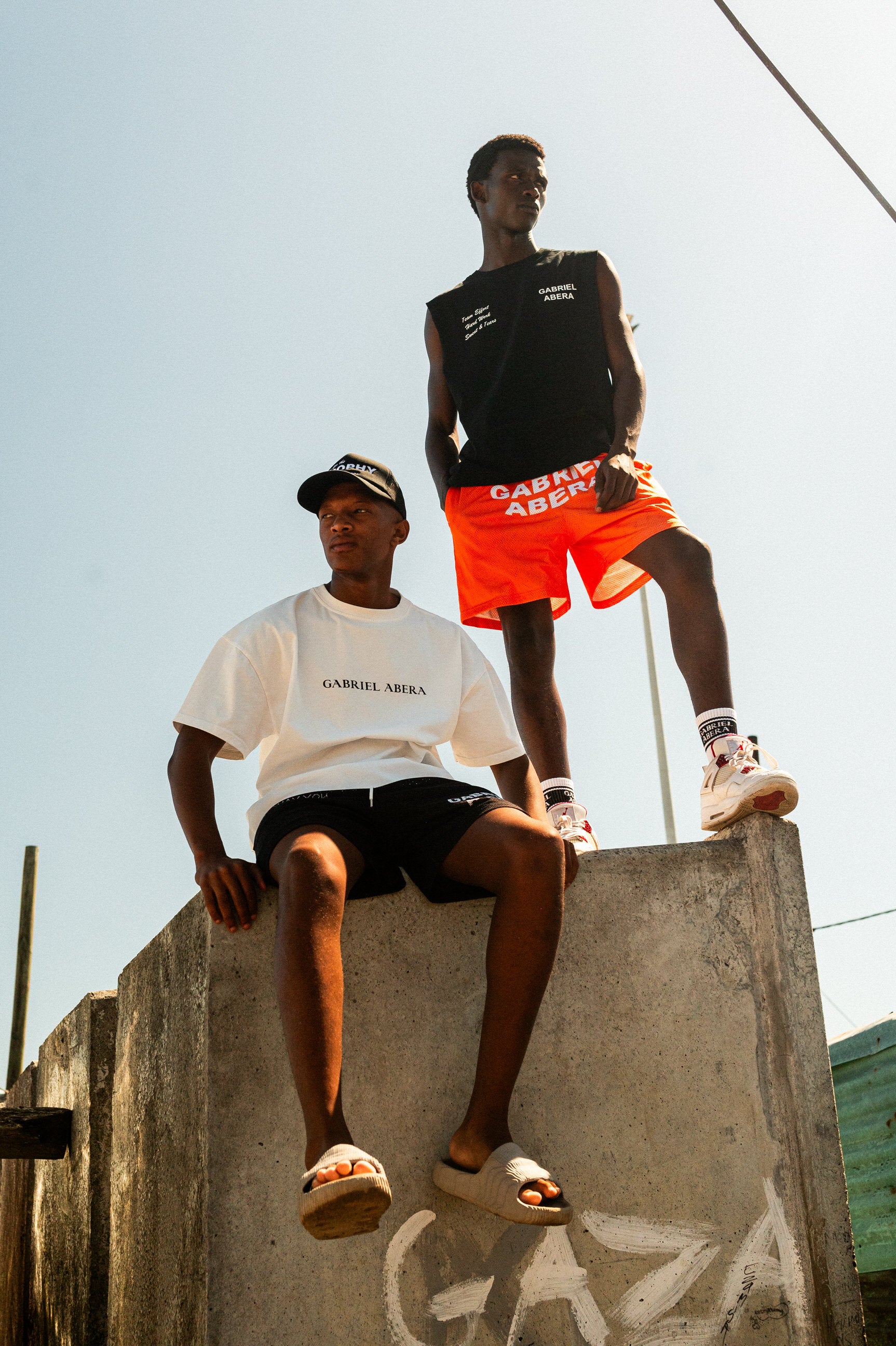 Model in orange Mesh Shorts von GABRIEL ABERA im Township Style in Kapstadt.