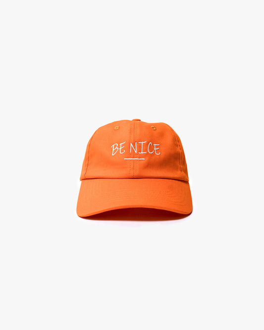 Orange cap with "be nice" writing on the front