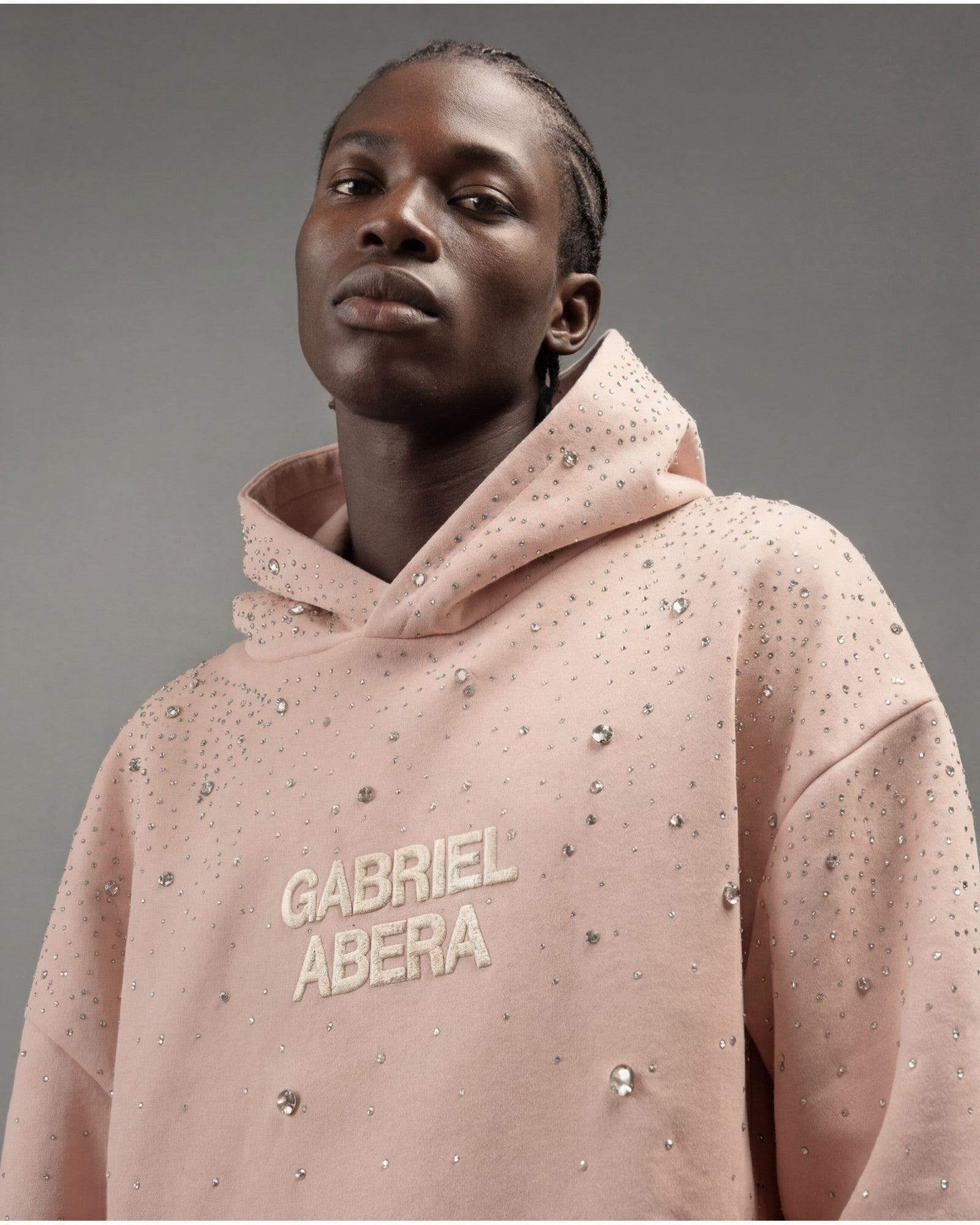 Male model wearing rosa rhinestone hoodie by GABRIEL ABERA front view oversized fit with hand-applied crystals GABRIEL ABERA streetwear