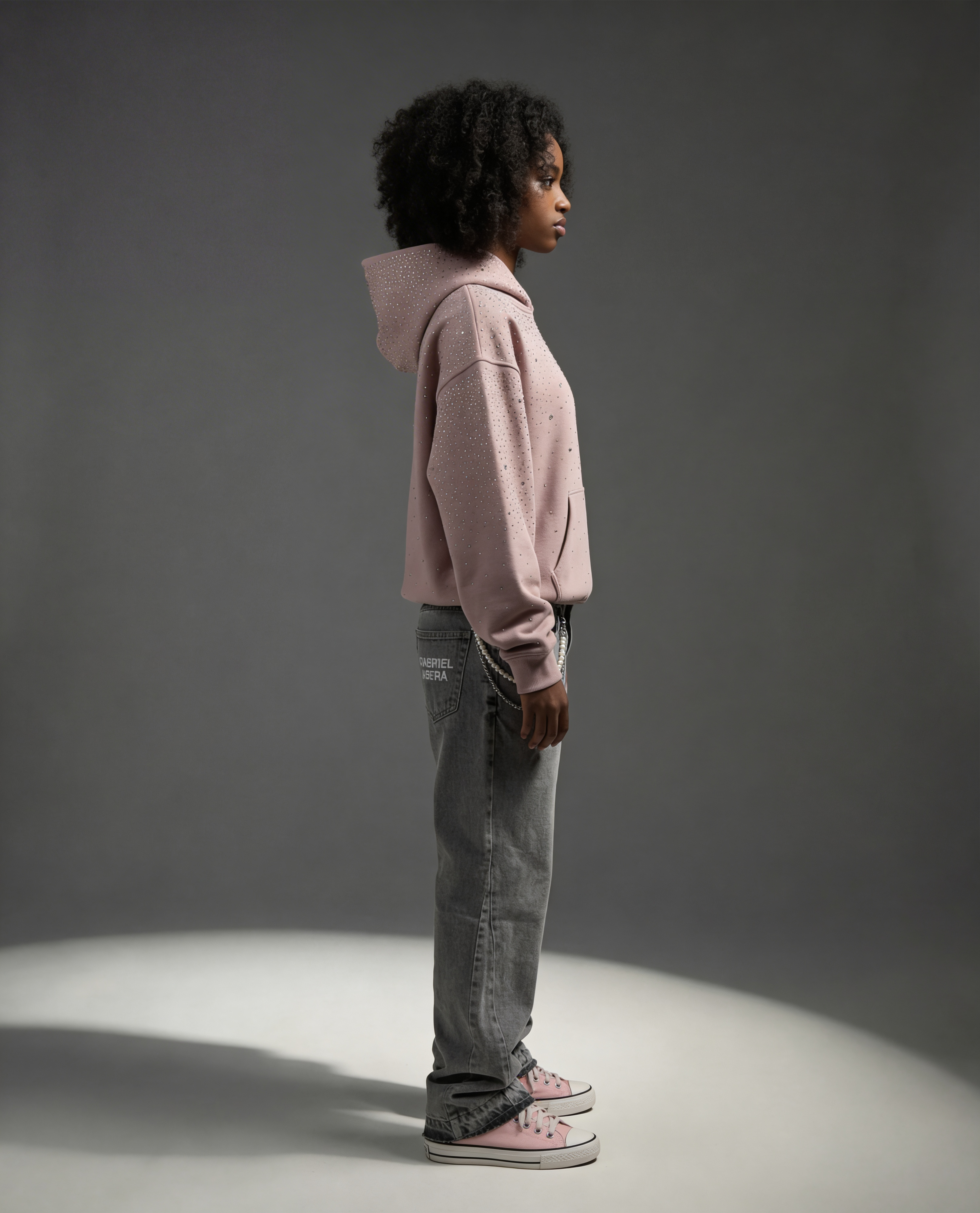 Female model full body wearing rosa rhinestone hoodie with jeans by Gabriel Abera showing full outfit styling premium streetwear look