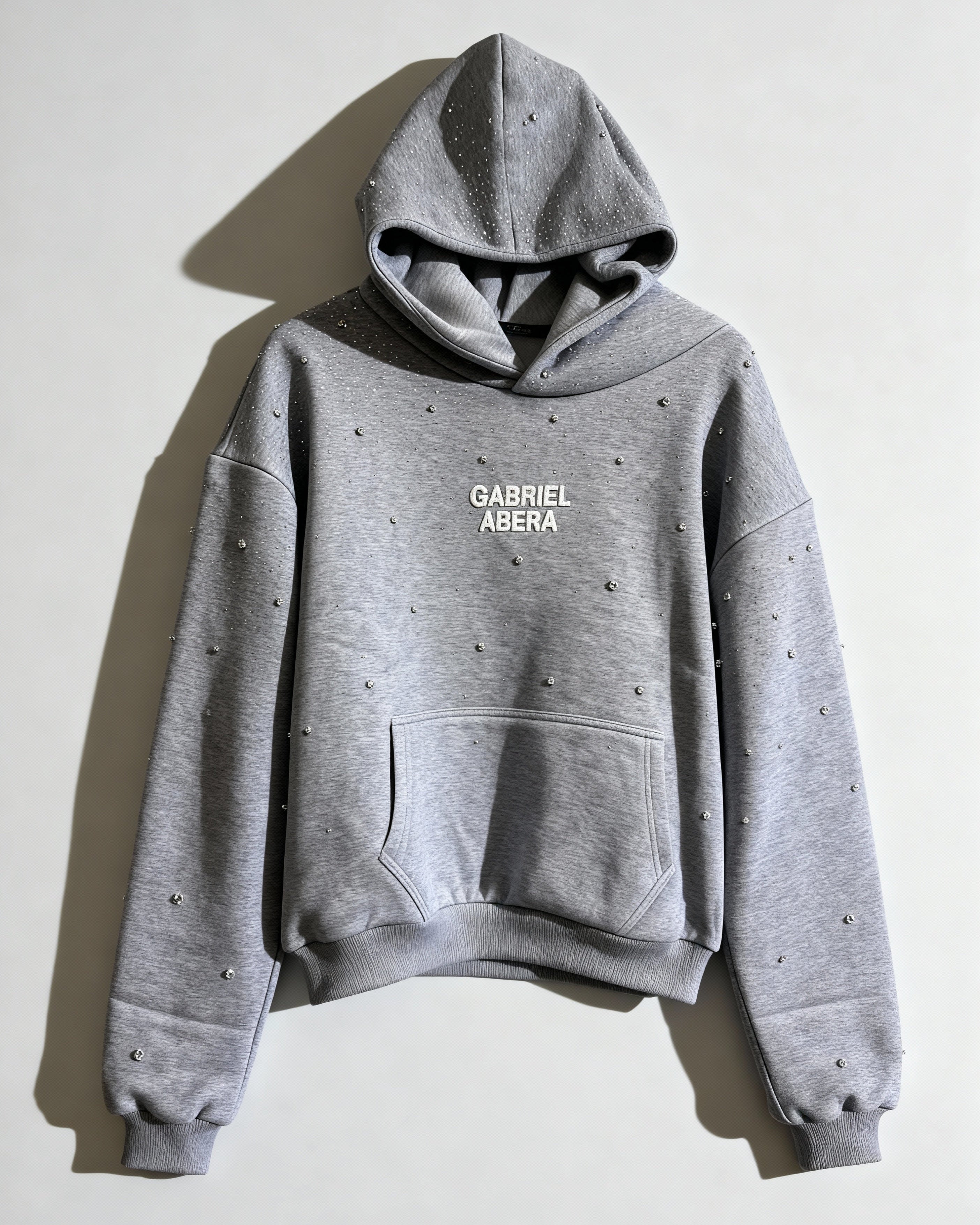 GABRIEL ABERA Rhinestone Hoodie in Grau – Frontansicht, handgesetzte Rhinestones über Brust und Ärmel, oversized Streetwear Fit.