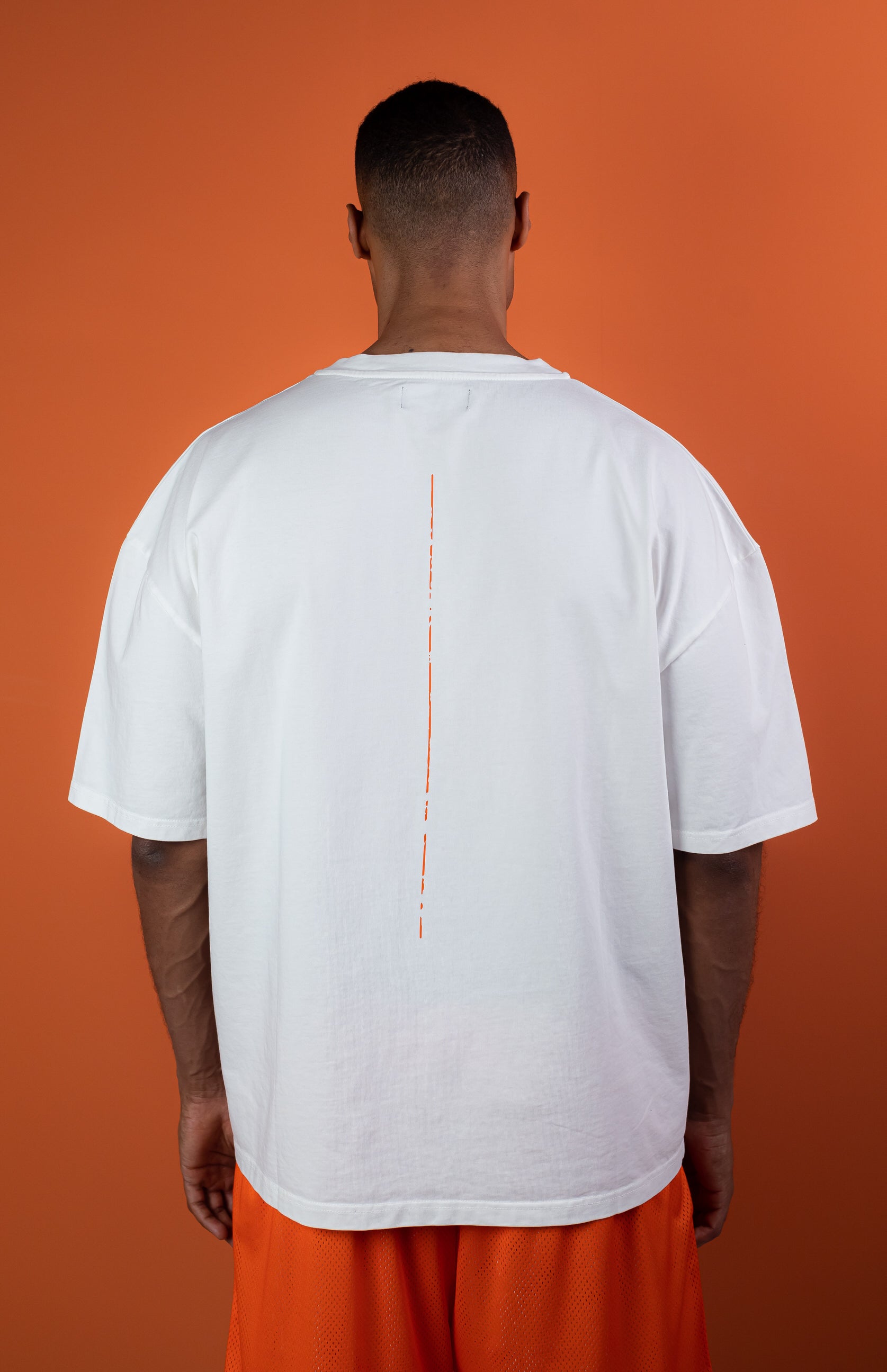Male Model wearing White oversize tshirt with orange trace on the back