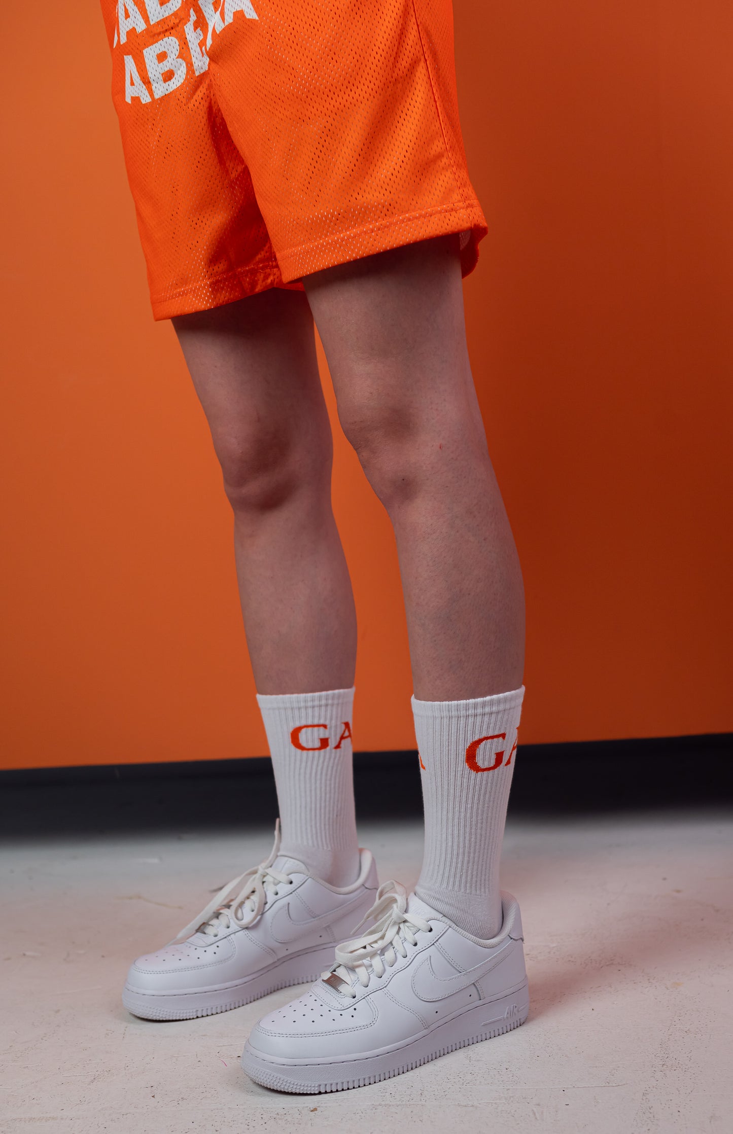 Model wearing A pair of socks with capital letters GA in orange 