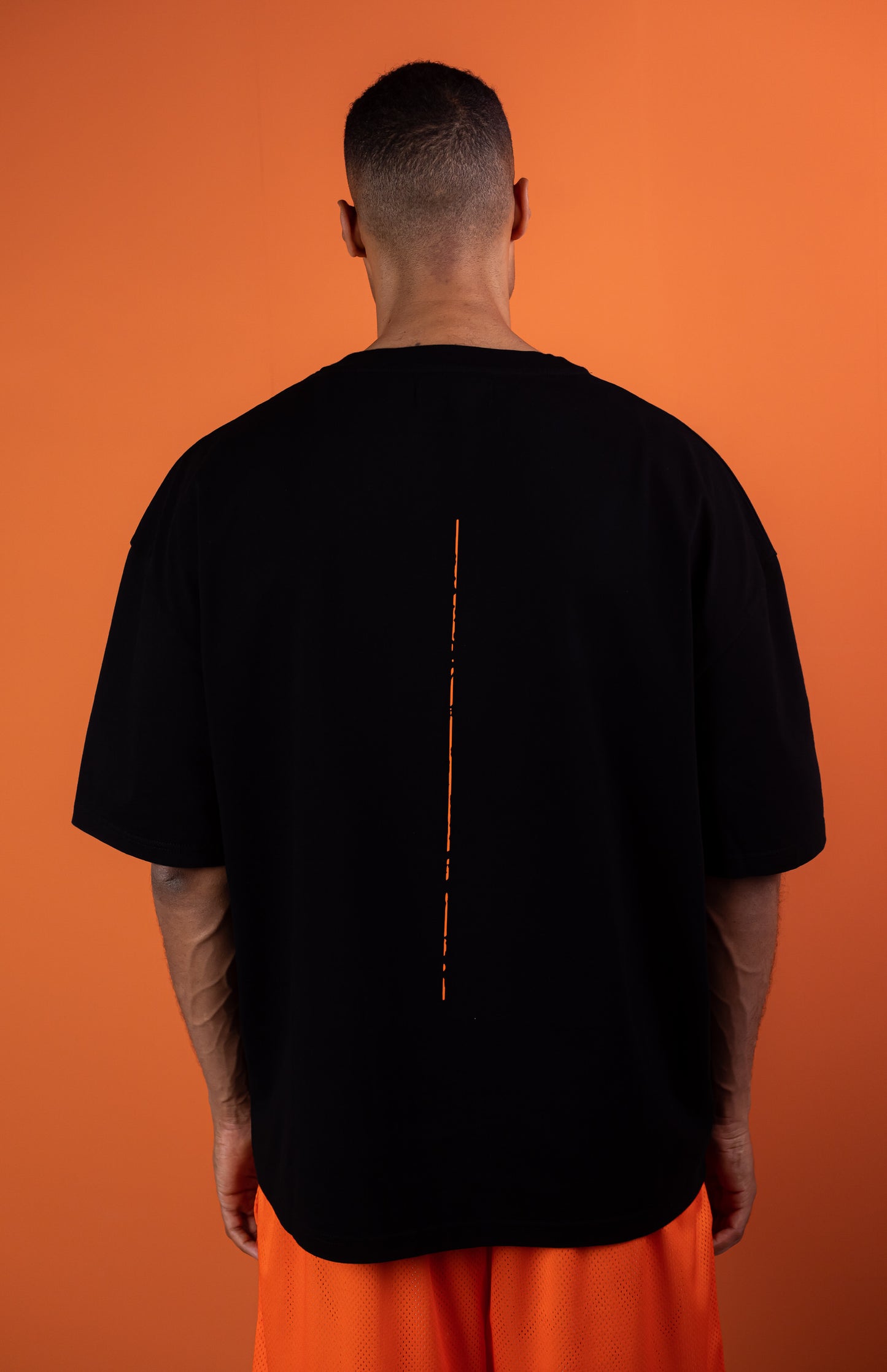 model wearing black oversie tshirt with orange trace