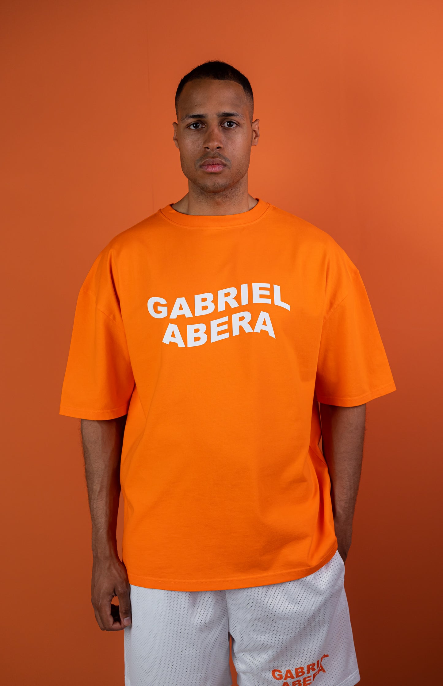 Model wearing a orange oversize tshirt with whitewavy brand name design