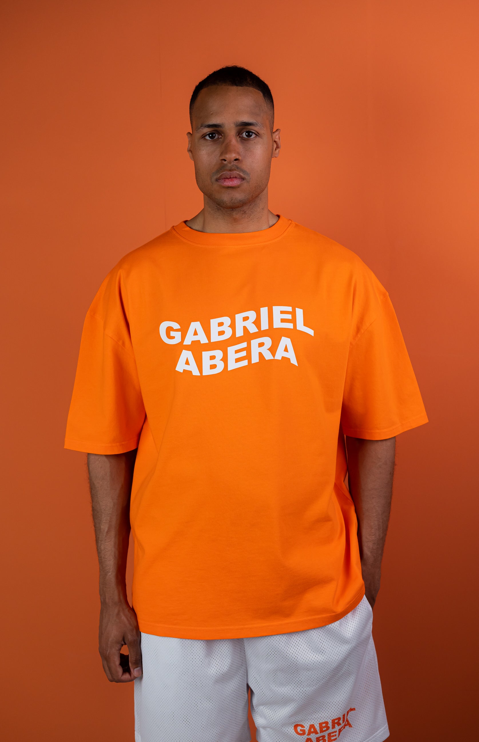 Model wearing a orange oversize tshirt with whitewavy brand name design