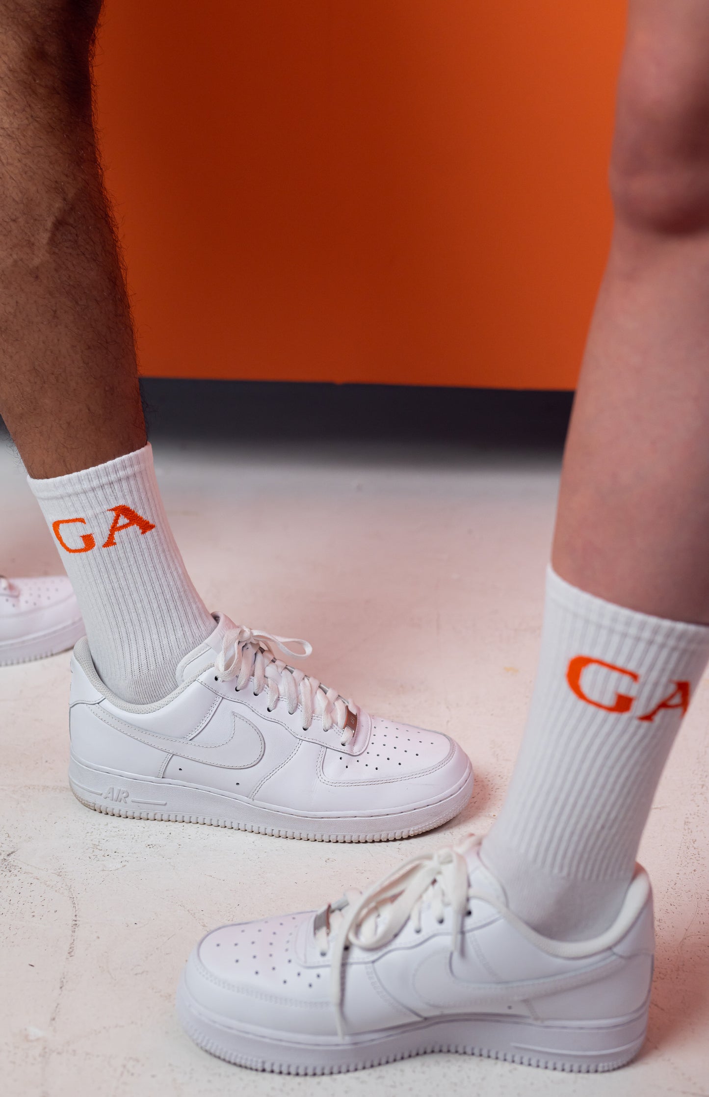 Model wearing A pair of socks with capital letters GA in orange 