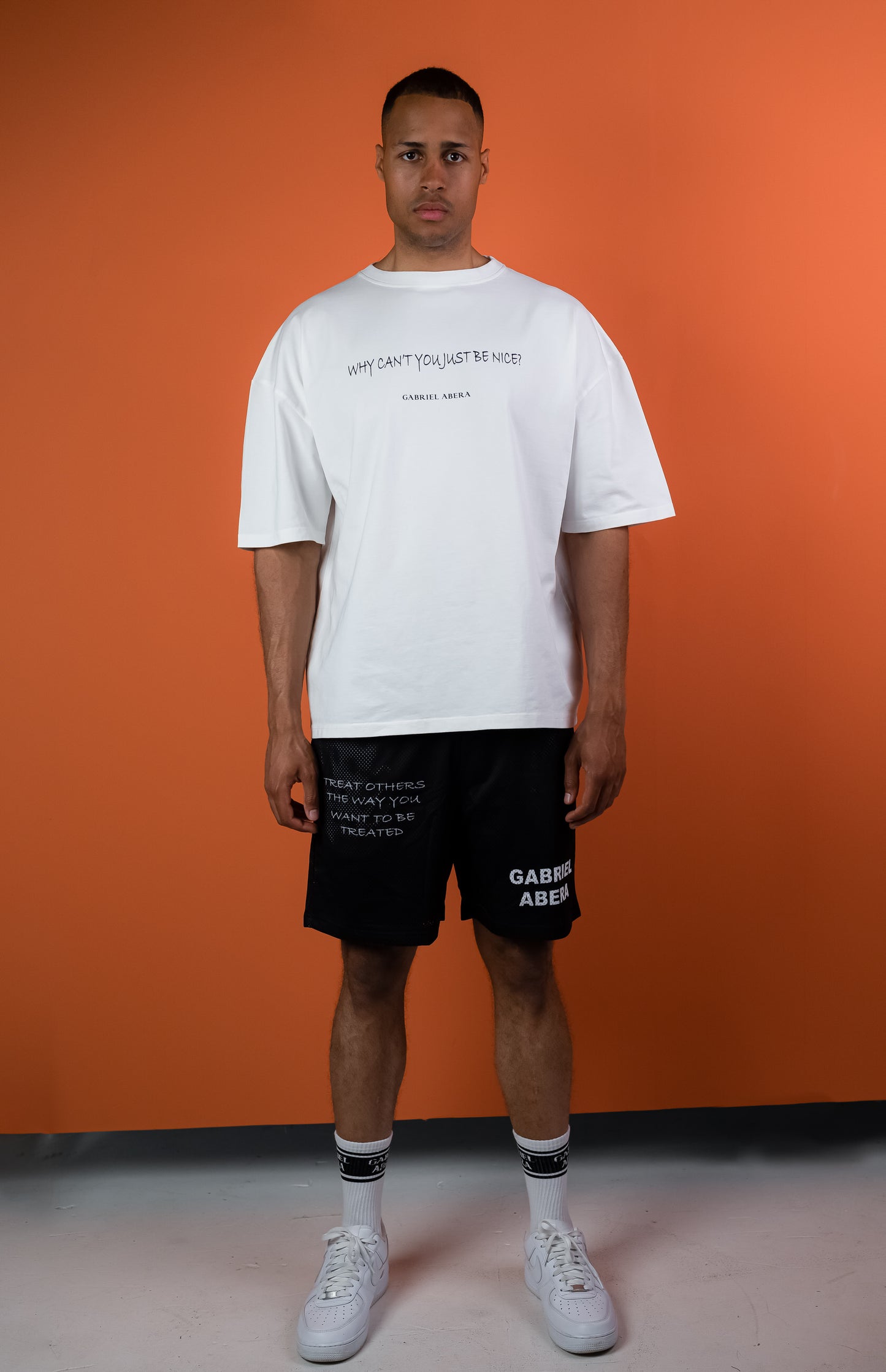 Male model wearing Black mesh shorts with statement print and brandname on the front
