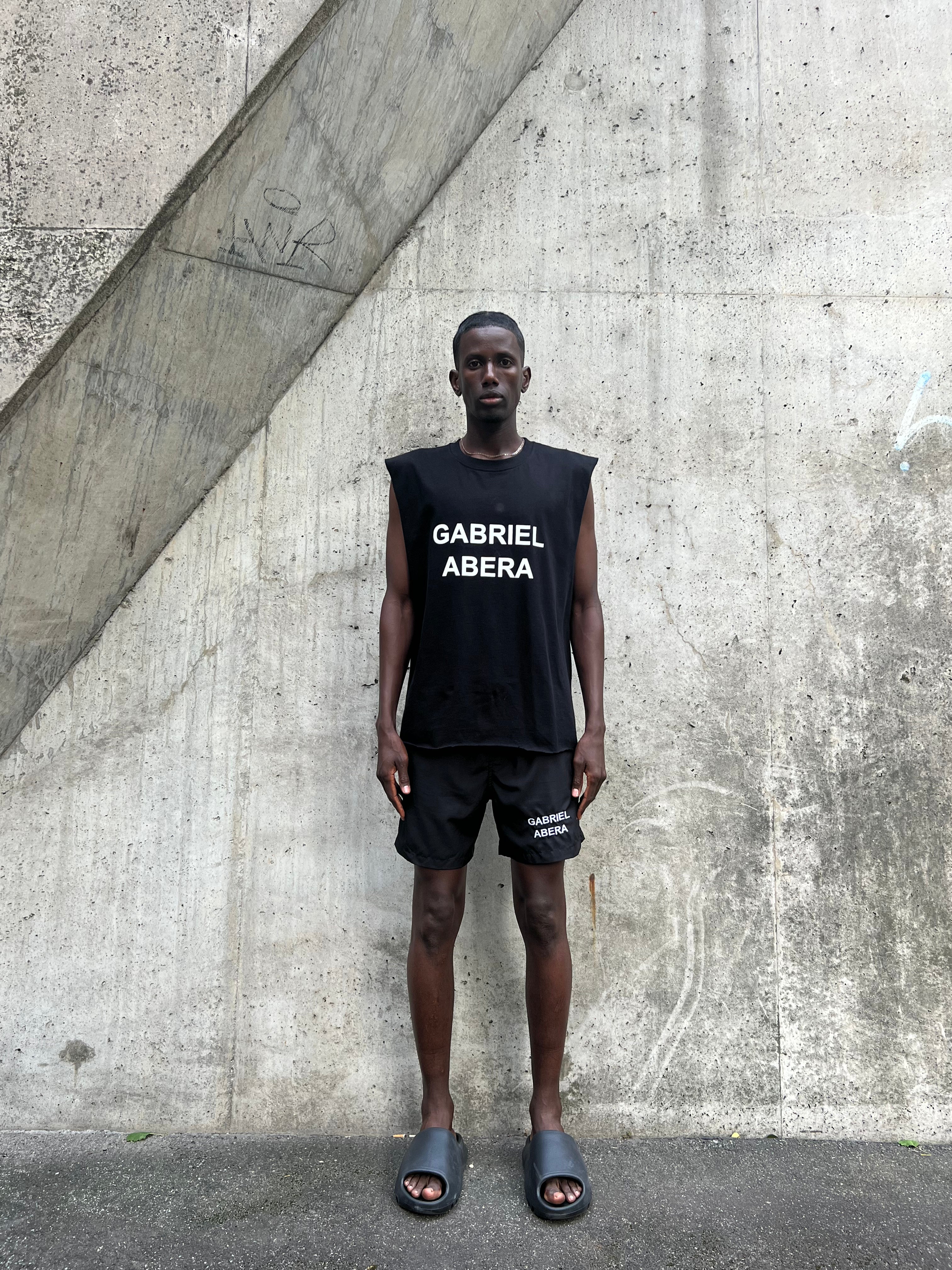 Model in black tank with white logo – Streetwear Sommerlook