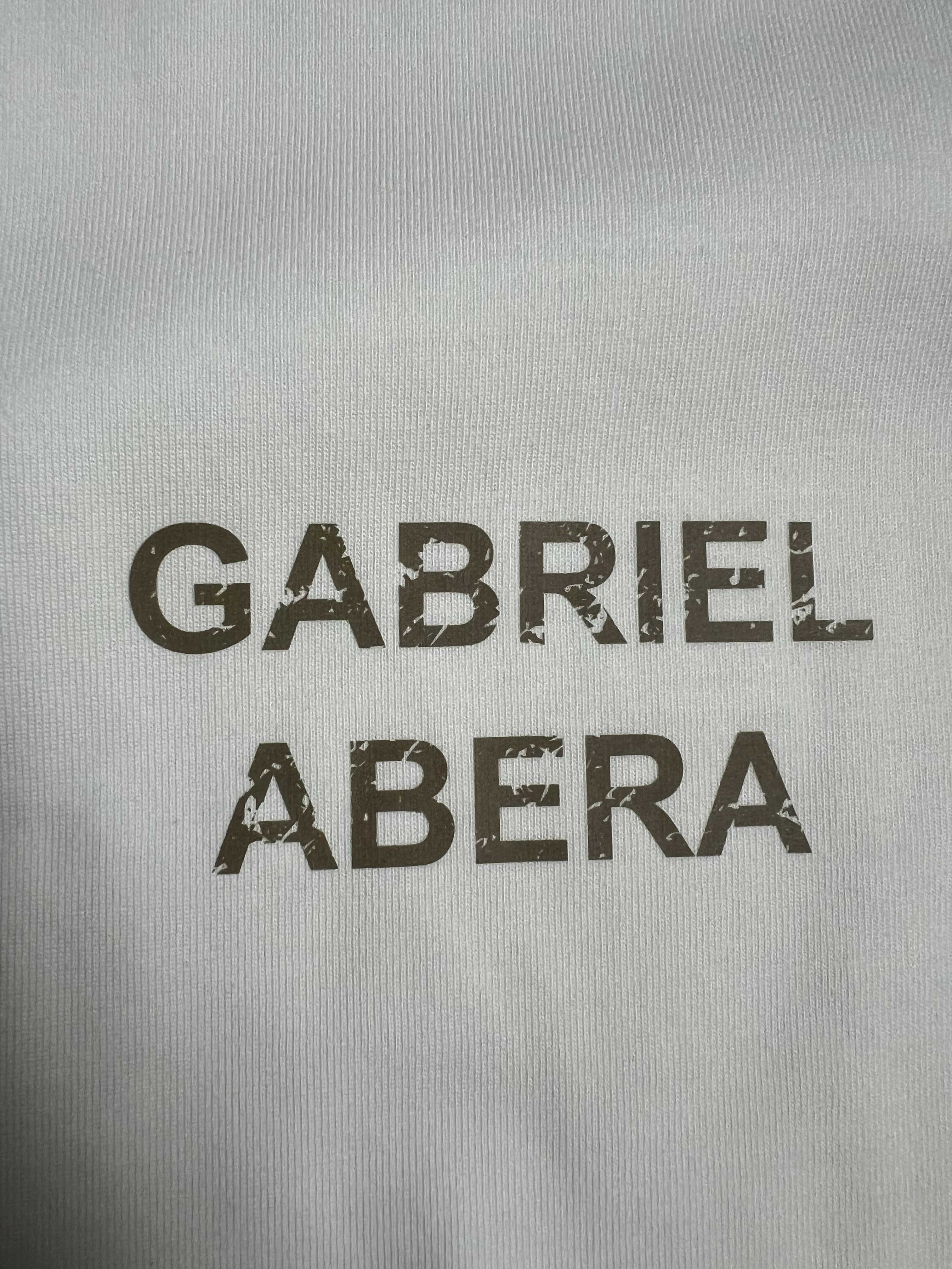 Close-up of khaki GA logo printed on cream white cotton t-shirt