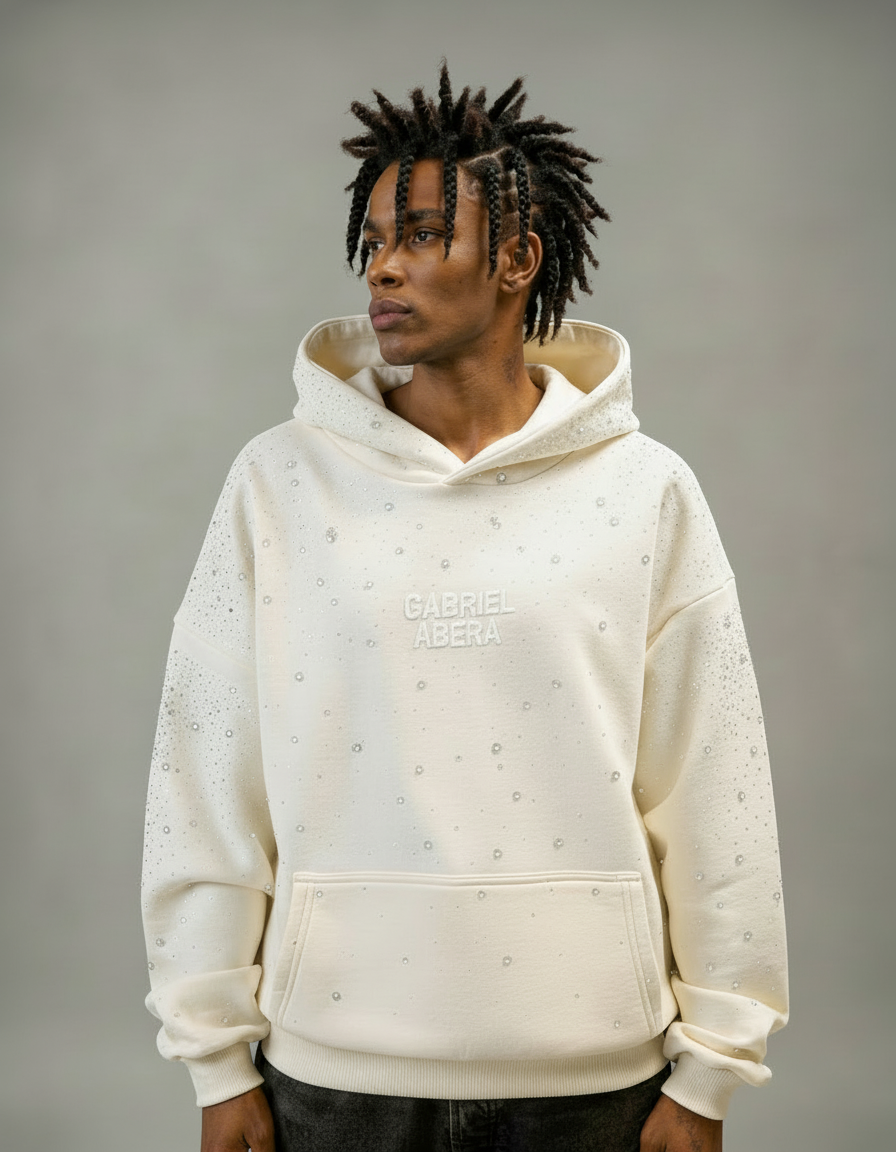 Männliches Model trägt GABRIEL ABERA Rhinestone Hoodie in Cream White – Frontansicht mit handgesetzten Rhinestones, Oversized Premium Streetwear