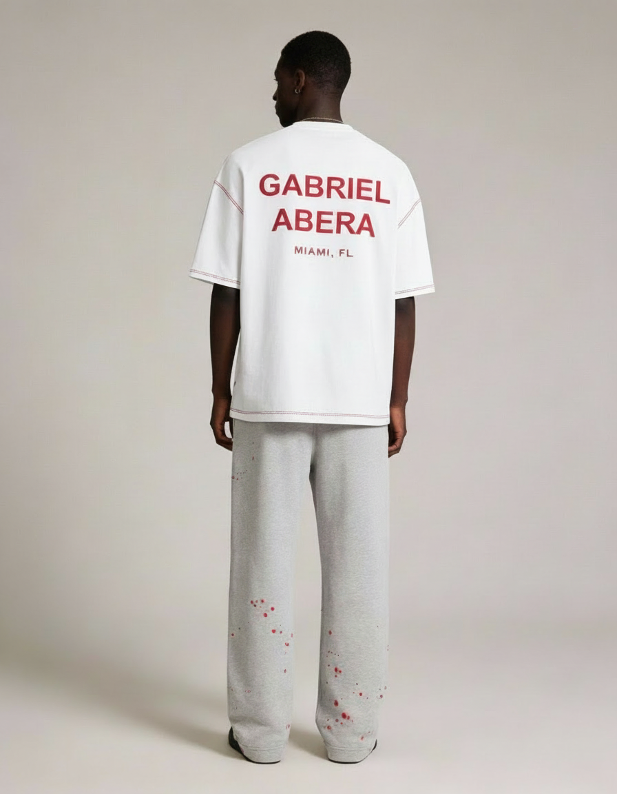 Rückansicht des weißen GABRIEL ABERA WHO NEEDS LOVE T-Shirts auf männlichem Model, minimalistisches Design und entspannter Schnitt