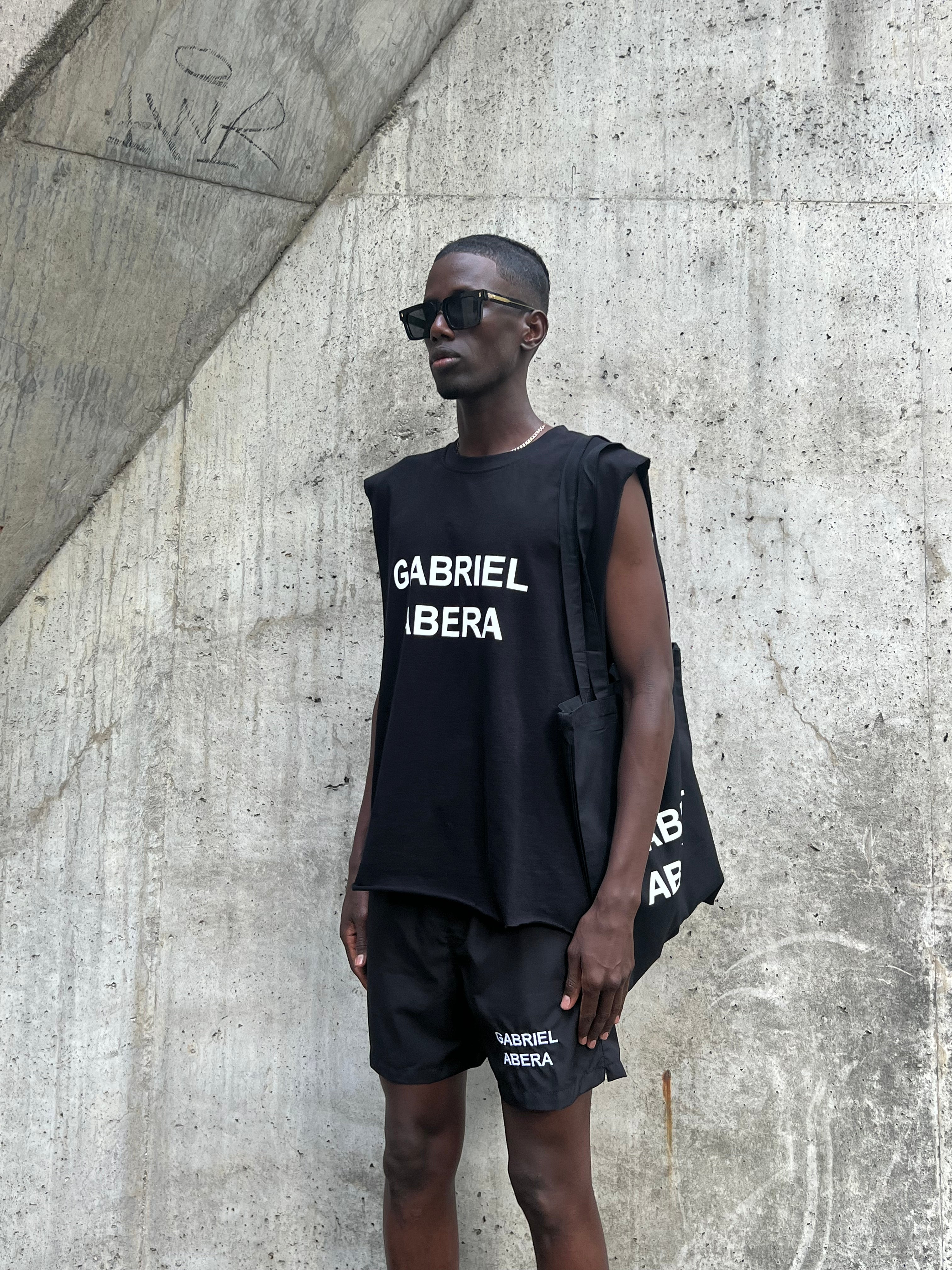 Model in black swim shorts with white Gabriel Abera Stick 