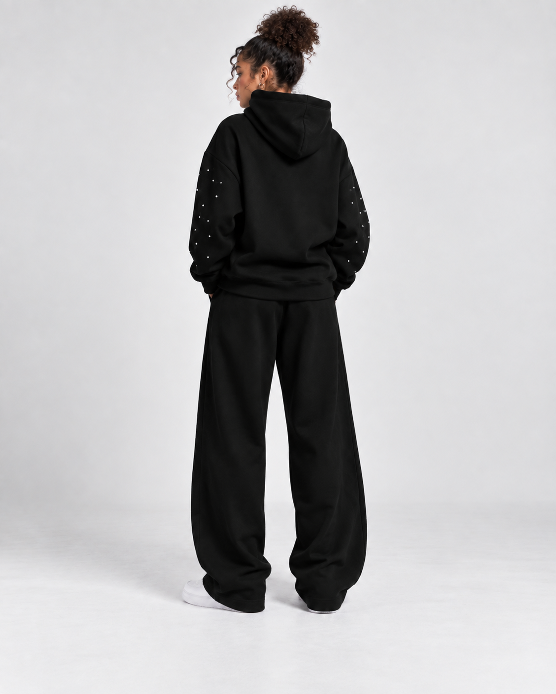 Rückansicht des schwarzen GABRIEL ABERA Astral Hoodies mit passender Jogginghose mit Strasssteinen veredelt im Oversized Streetwear Fit