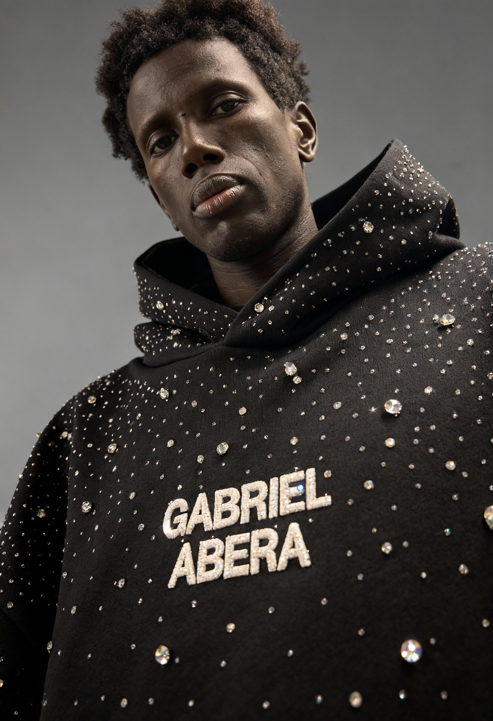 Detailaufnahme des schwarzen GABRIEL ABERA Rhinestone Hoodie – hochwertige Textur und einzeln gesetzte Rhinestones in Premium Streetwear Verarbeitung.